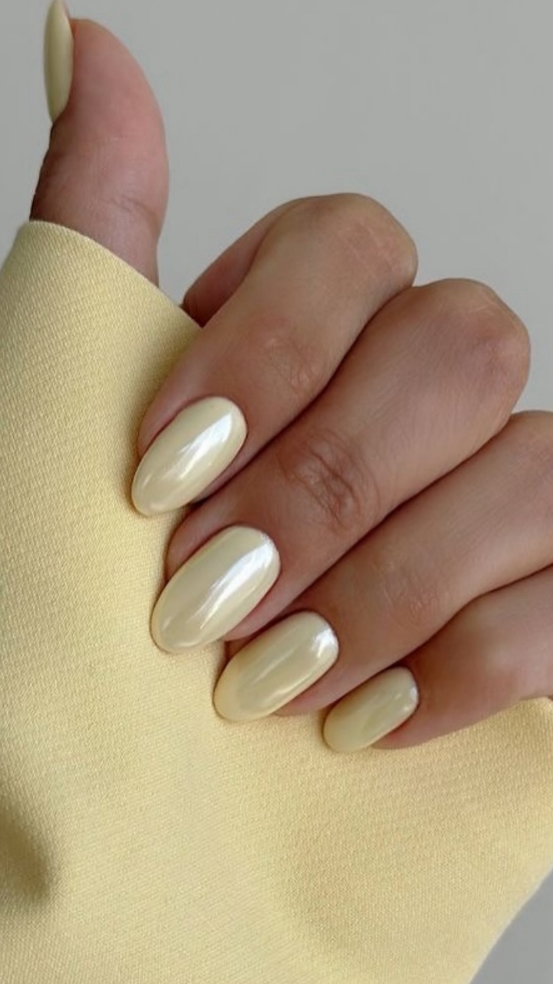 Buttercream yellow spring nails with glossy finish on short almond-shaped nails