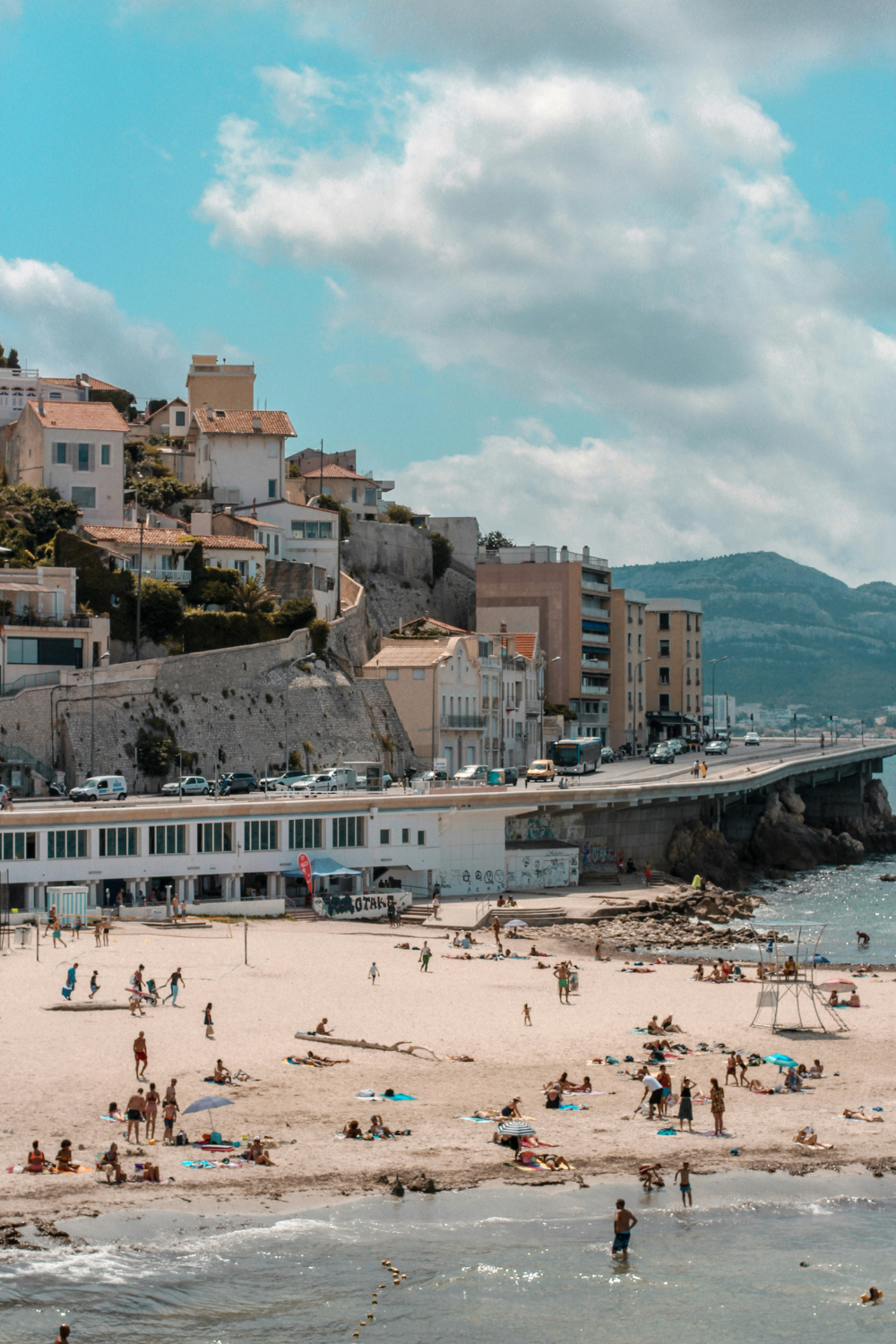 People swimming and relaxing at Plage des Catalans beach in Marseille, France
