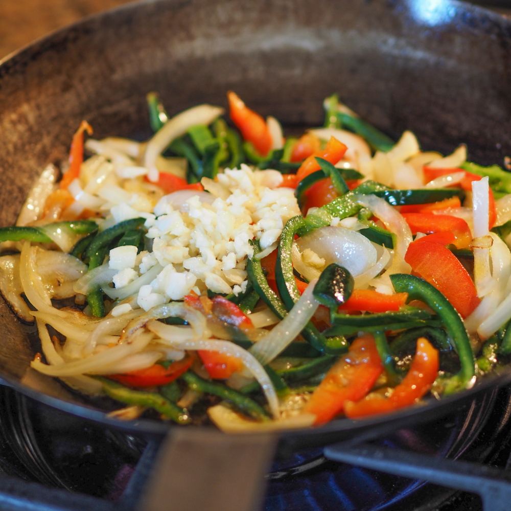 Onions, garlic, and peppers cooking in olive oil to make a flavorful sofrito for stuffed bell peppers
