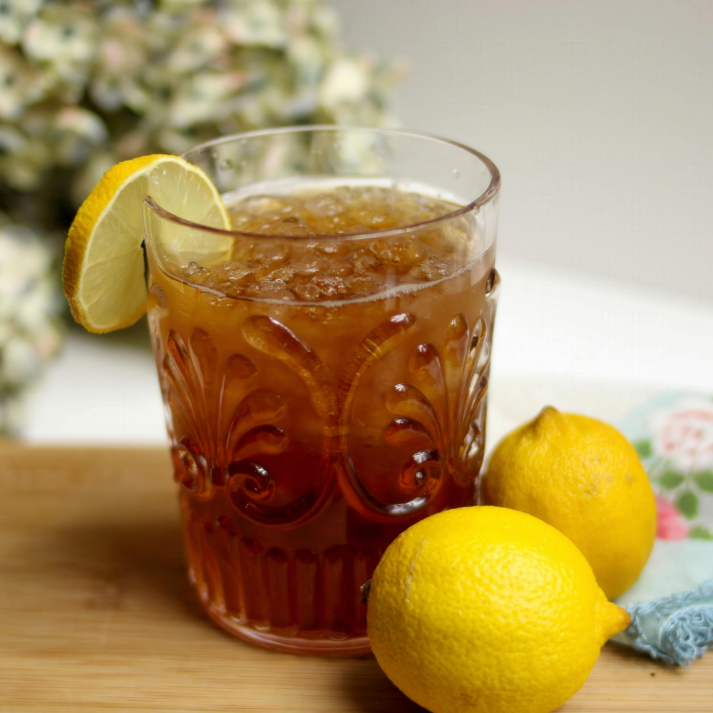 Basil lemonade iced black tea with fresh basil leaves and lemon slices.