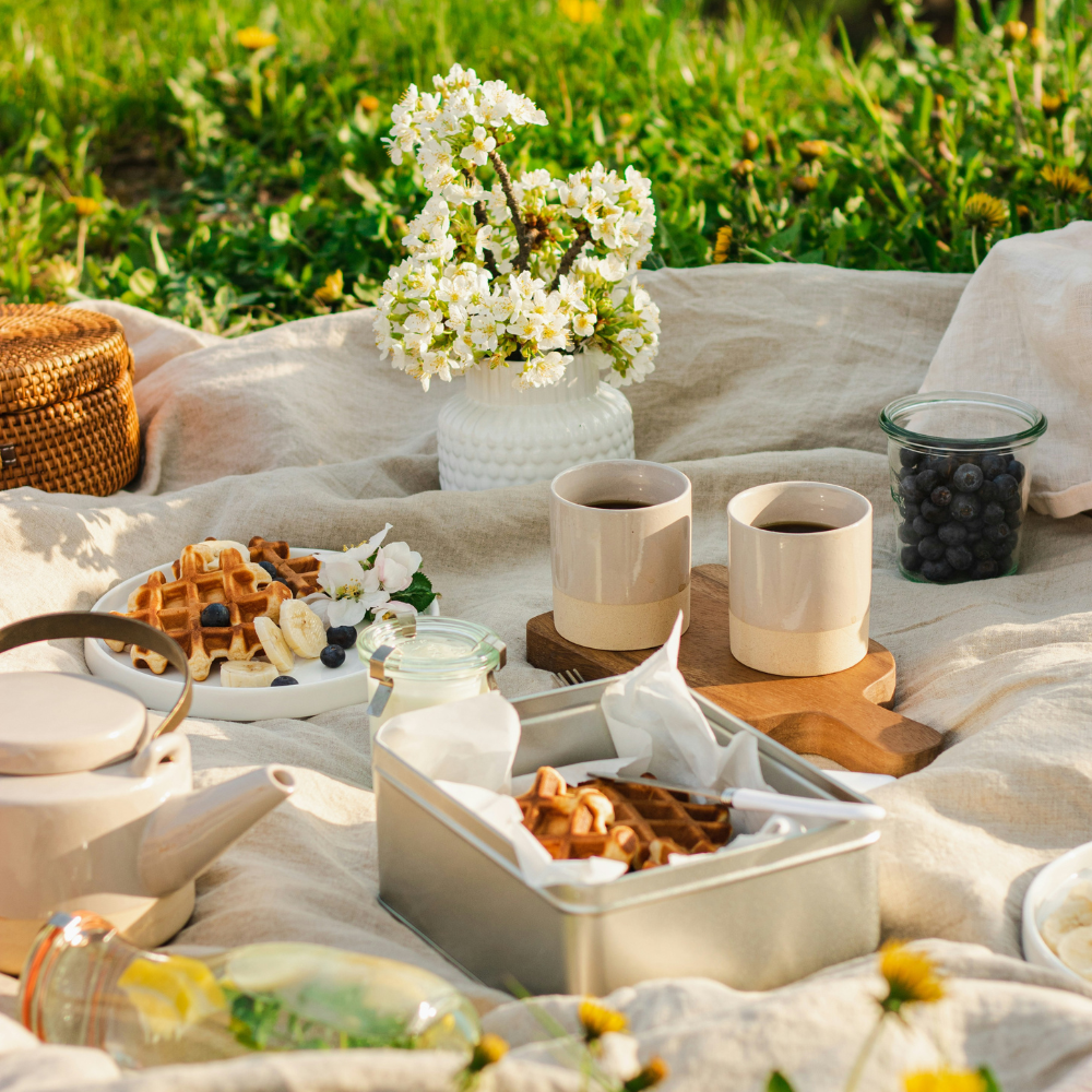 English tea garden party with floral tablecloth, pastries, and tea set in a garden setting
