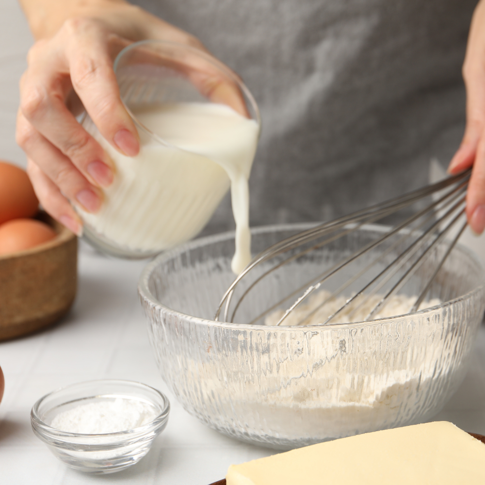 Folding dry ingredients into strawberry shortcake cake batter using a spatula.