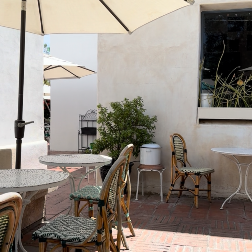 Outdoor courtyard dining at The Coronet Café in Tucson with relaxed atmosphere and greenery.