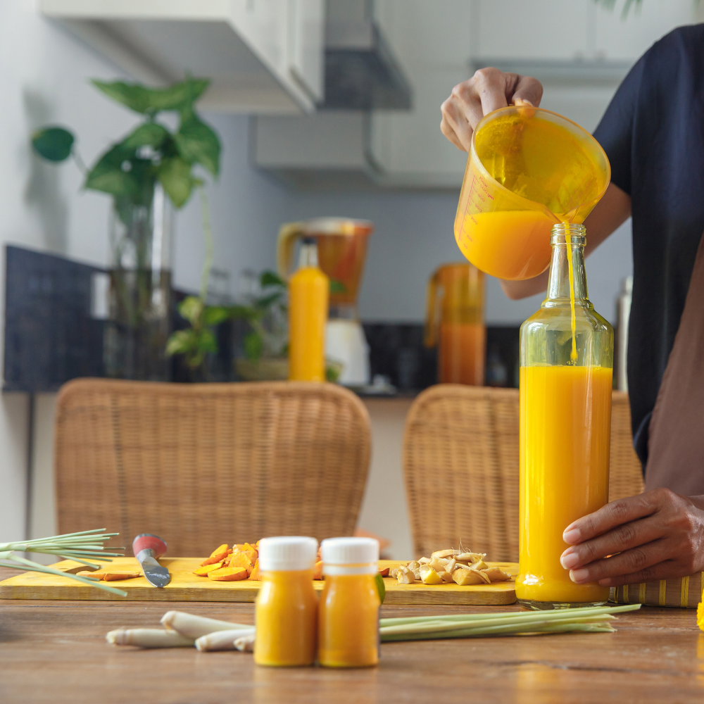 Straining blended ginger turmeric shots through a fine mesh strainer for a smooth texture.