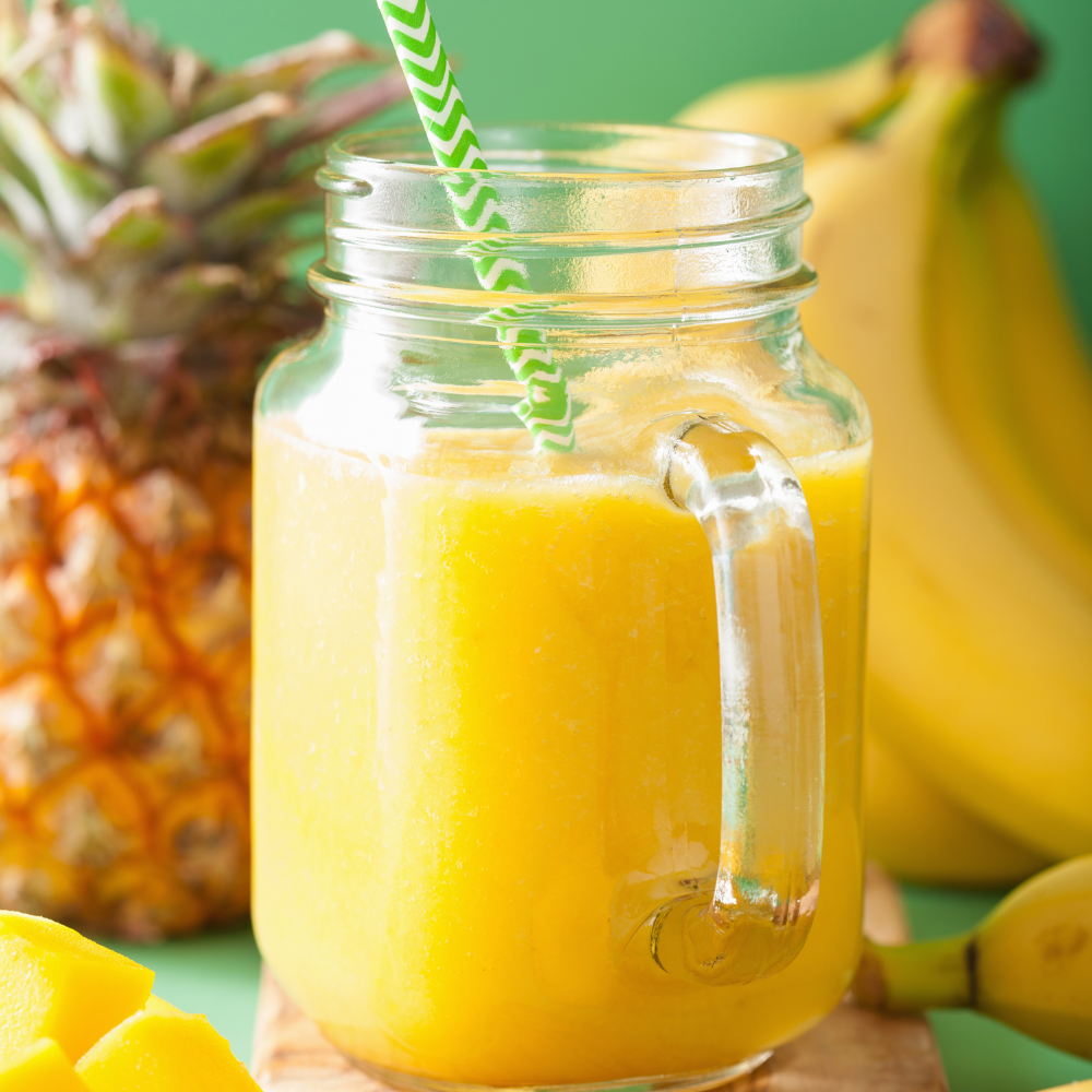 Healthy mango smoothie served for breakfast with fresh fruit on the side.