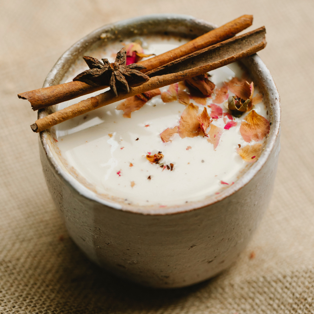 Steamed milk being poured into spiced chai tea.
