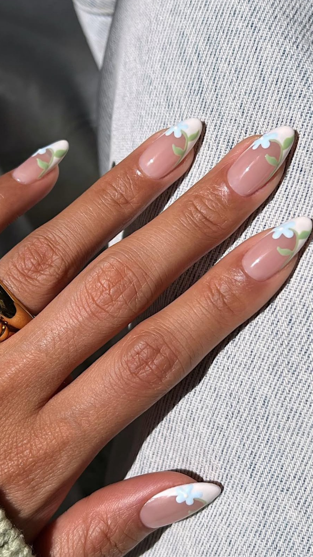 Spring nail design with tiny white floral accents on nude base