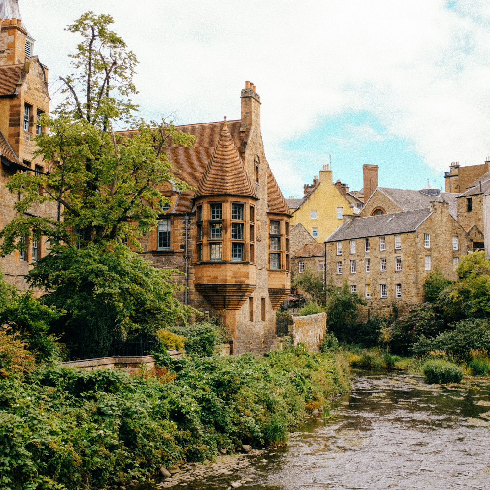 Picturesque Dean Village with stone façades and canal waters in Edinburgh, Scotland.
