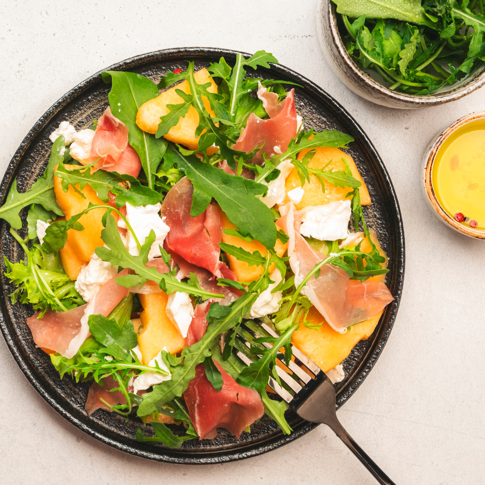Cantaloupe prosciutto salad with fresh arugula, lemon juice, and olive oil