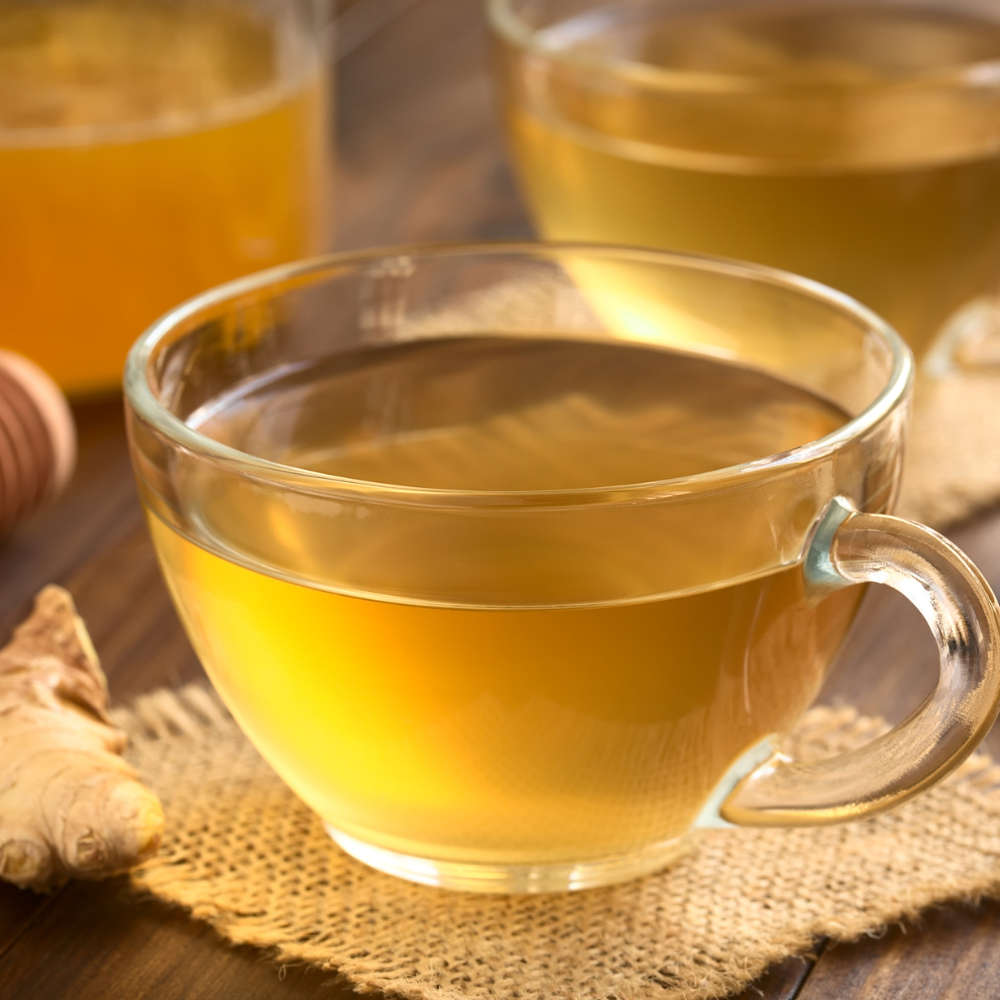 Homemade fresh ginger tea in a cup, made from fresh ginger root, lemon, and honey, perfect for comfort and wellness.