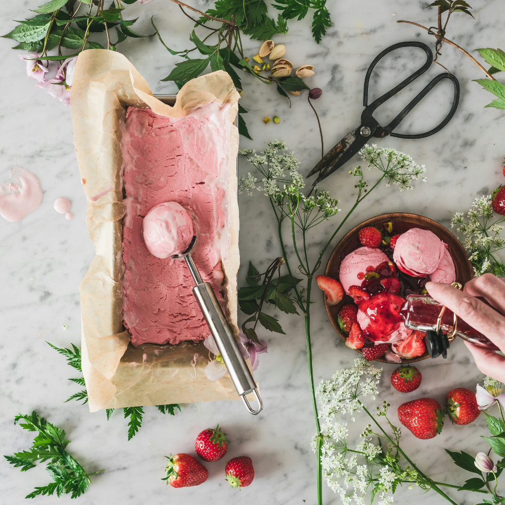 DIY ice cream bar with toppings and pastel decor at a summer garden party