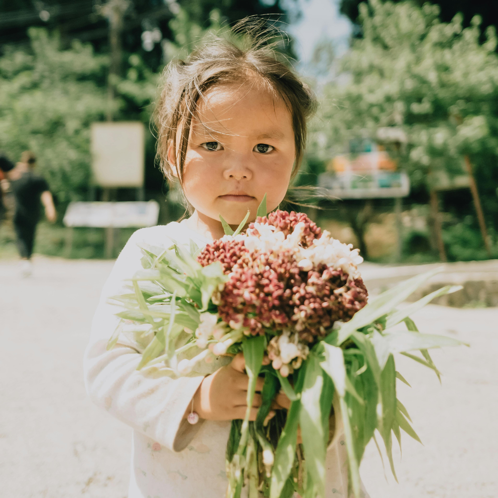 Buying yourself fresh flowers at a summer market as a self-care moment.