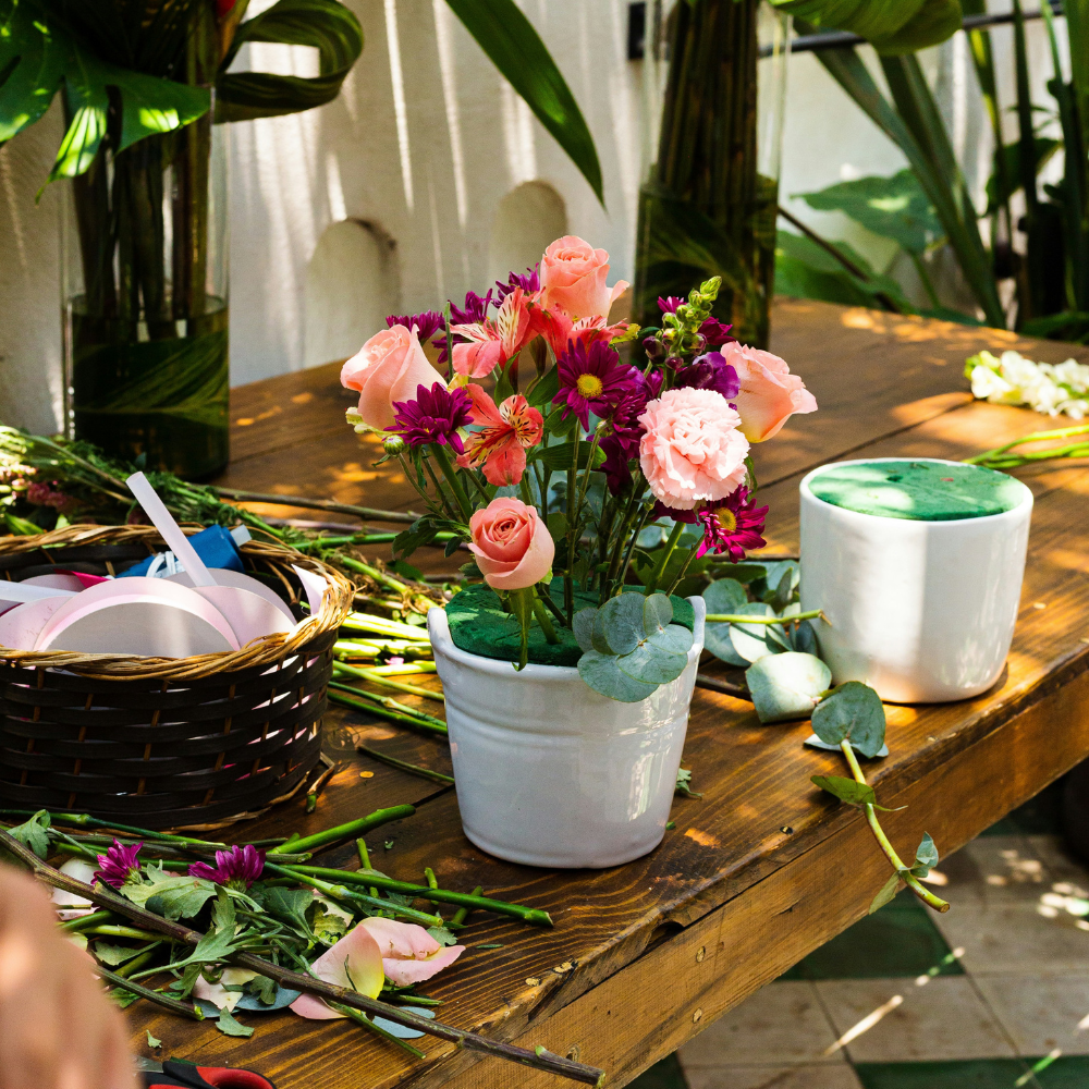 DIY flower arranging bar with fresh blooms for guests at a garden party