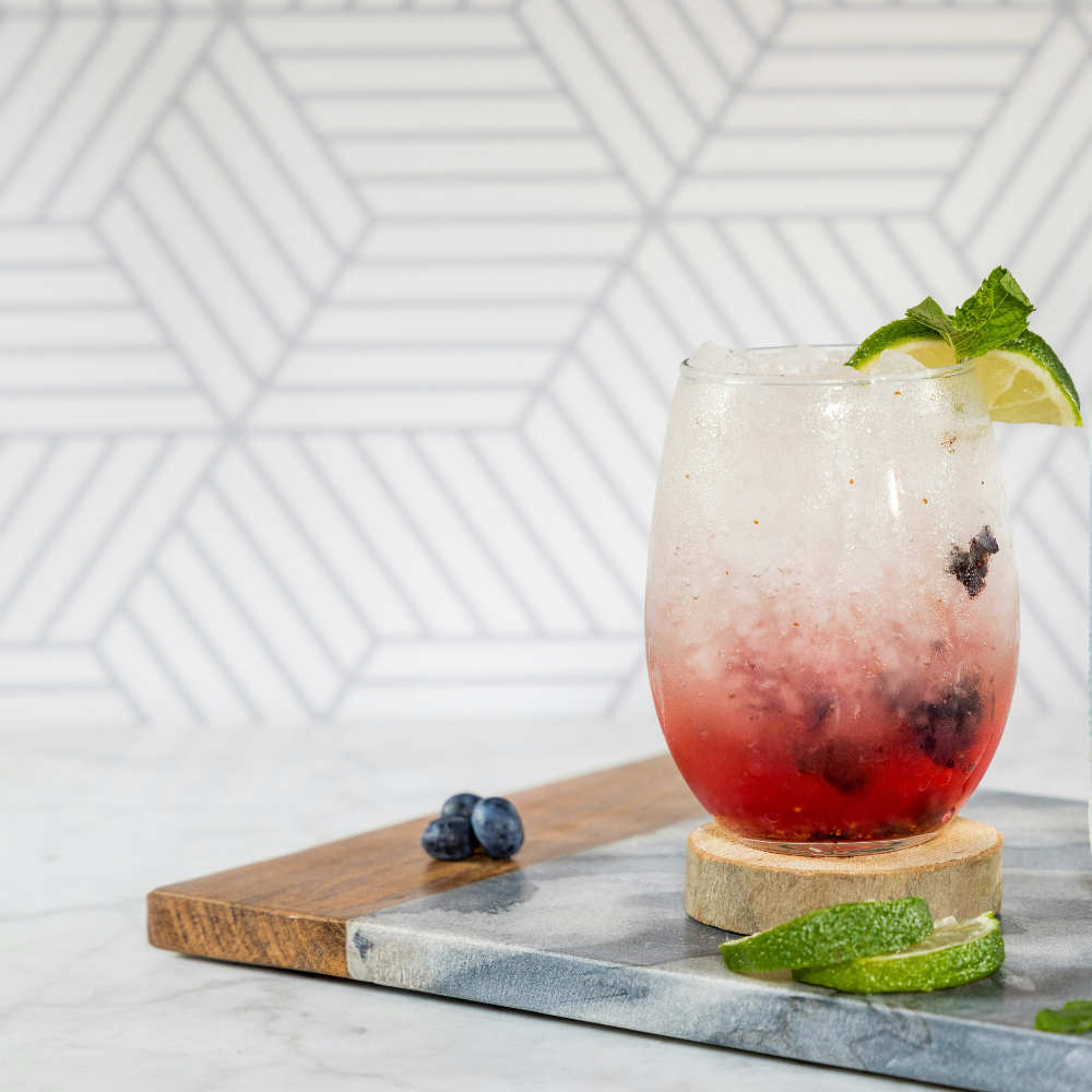 Blueberry mint non-alcoholic drink for summer with sparkling water, blueberries, mint, and ice cubes