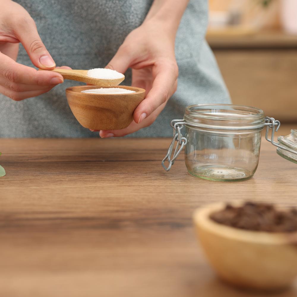 Adding and mixing ingredients to create a homemade DIY coffee scrub for soft skin