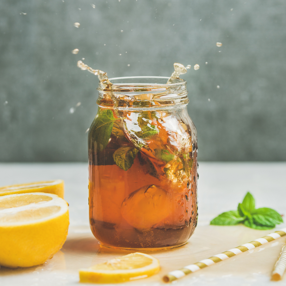 Iced green tea with rosemary sprig and fresh blackberries.