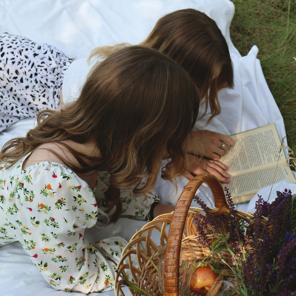Book club picnic with friends or couples reading, enjoying snacks, and discussing favorite books outdoors