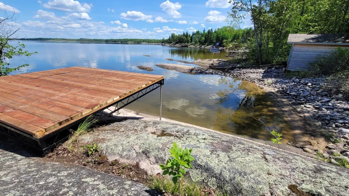 Everyone laughed when this simple deck went in on the Winnipeg River where the customer wanted it. It went in when the water was low so it seemed out of place perched up on the rock. 

This year our customer is the one laughing.

It may appear that t