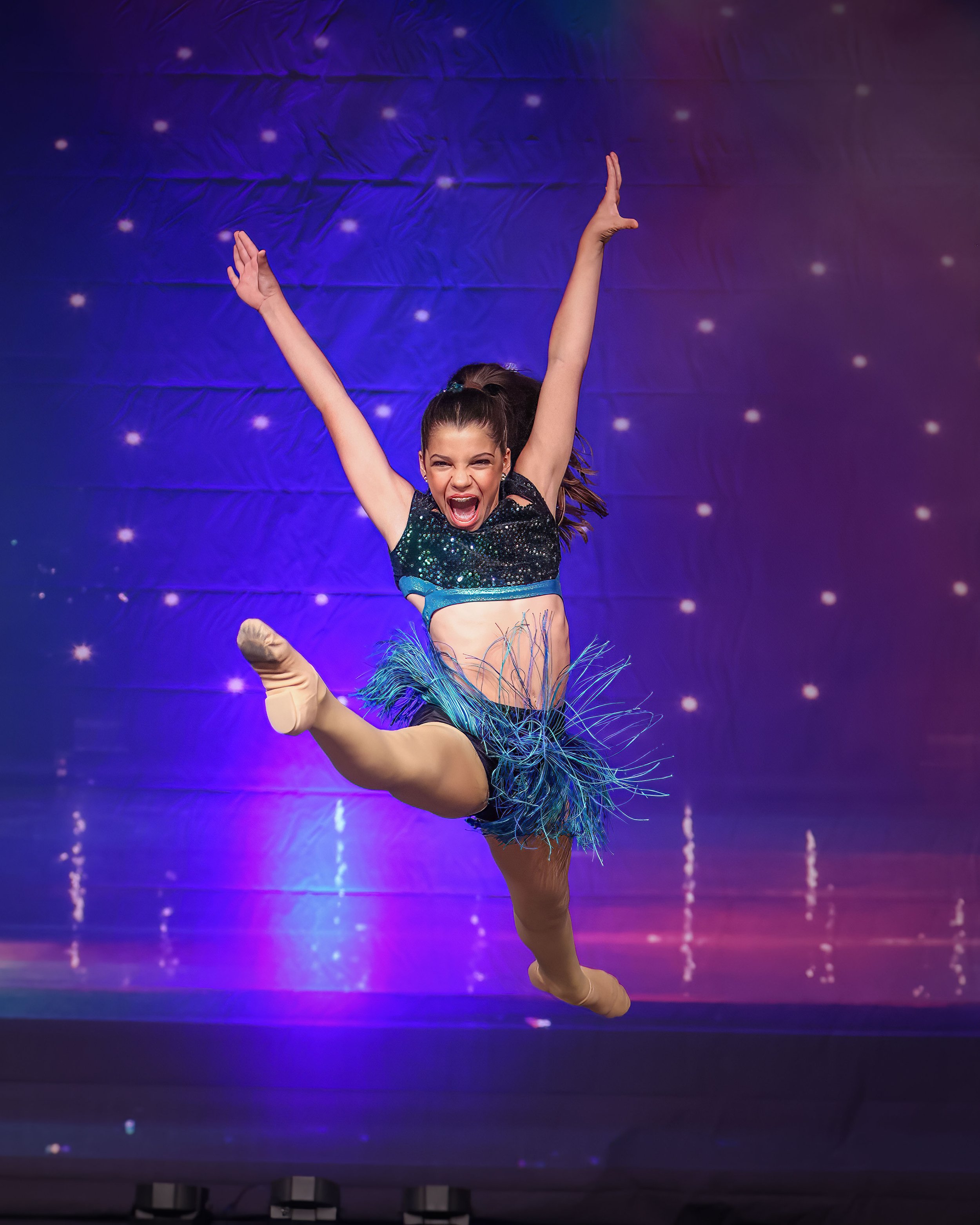 Competitive dancer performing a leap during a dance competition in Florida.