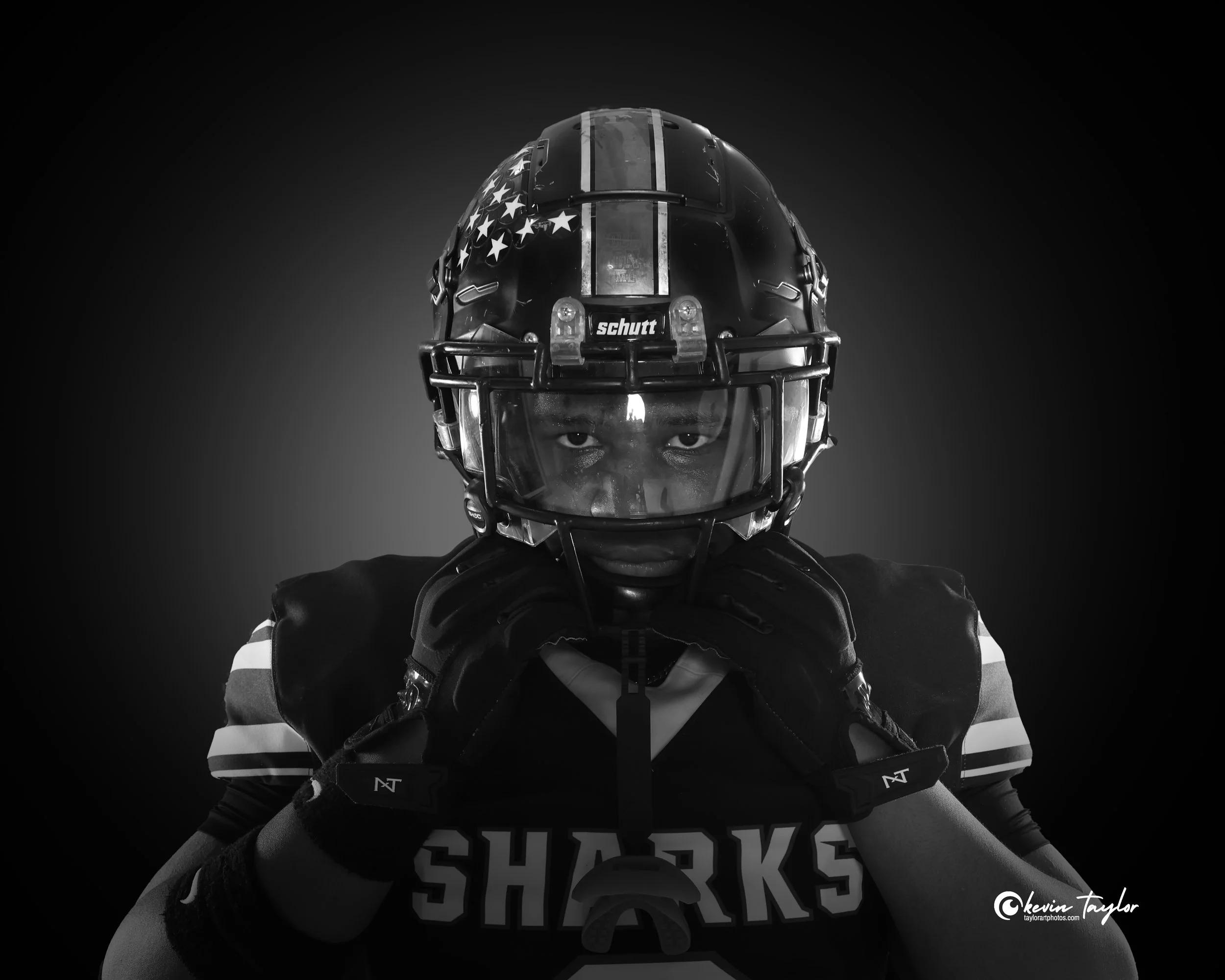 High school football player adjusting his helmet during a dramatic black-and-white sports portrait session in Florida.