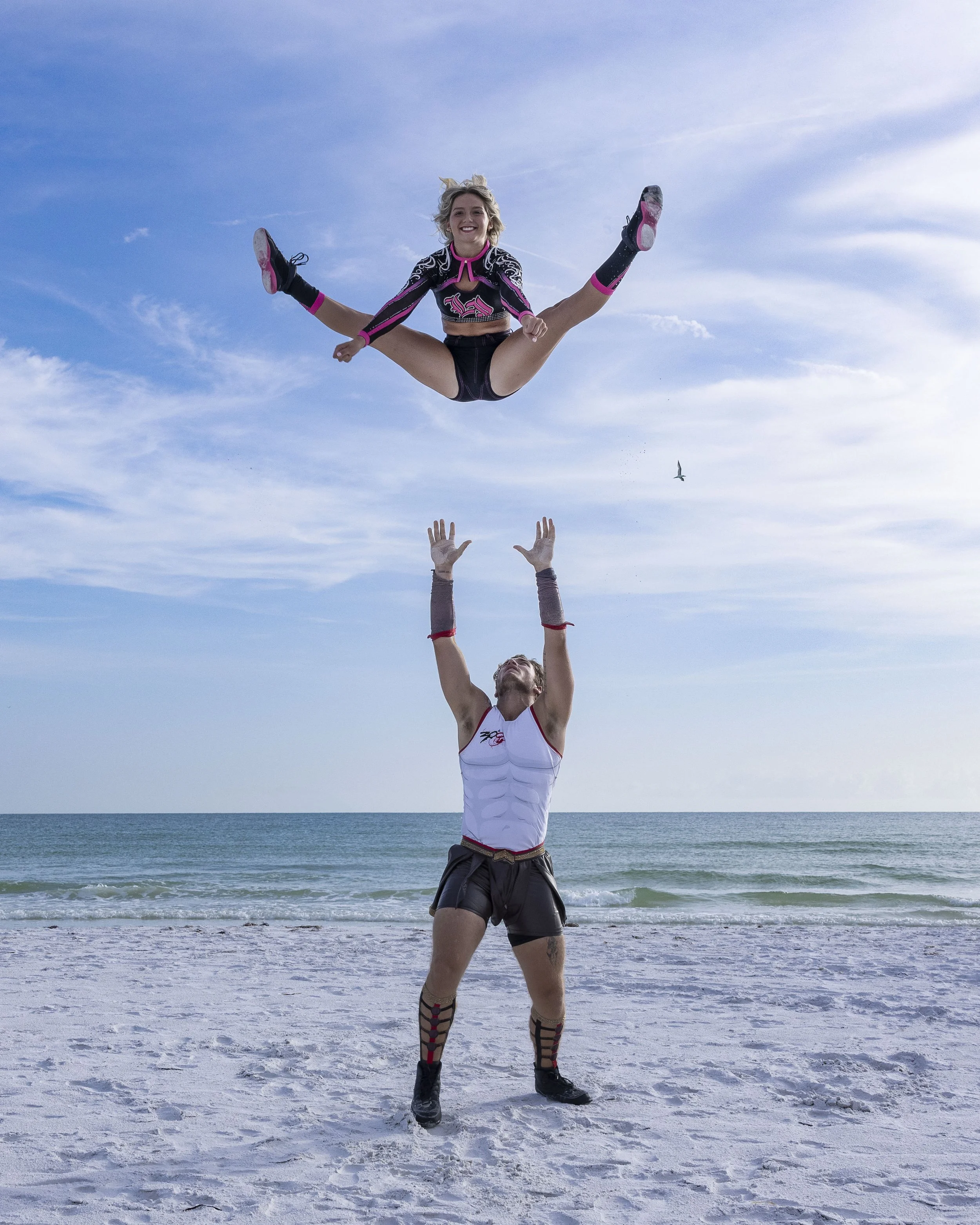 Top Gun All Stars athletes assist in a basket toss during a beach media day in Florida.