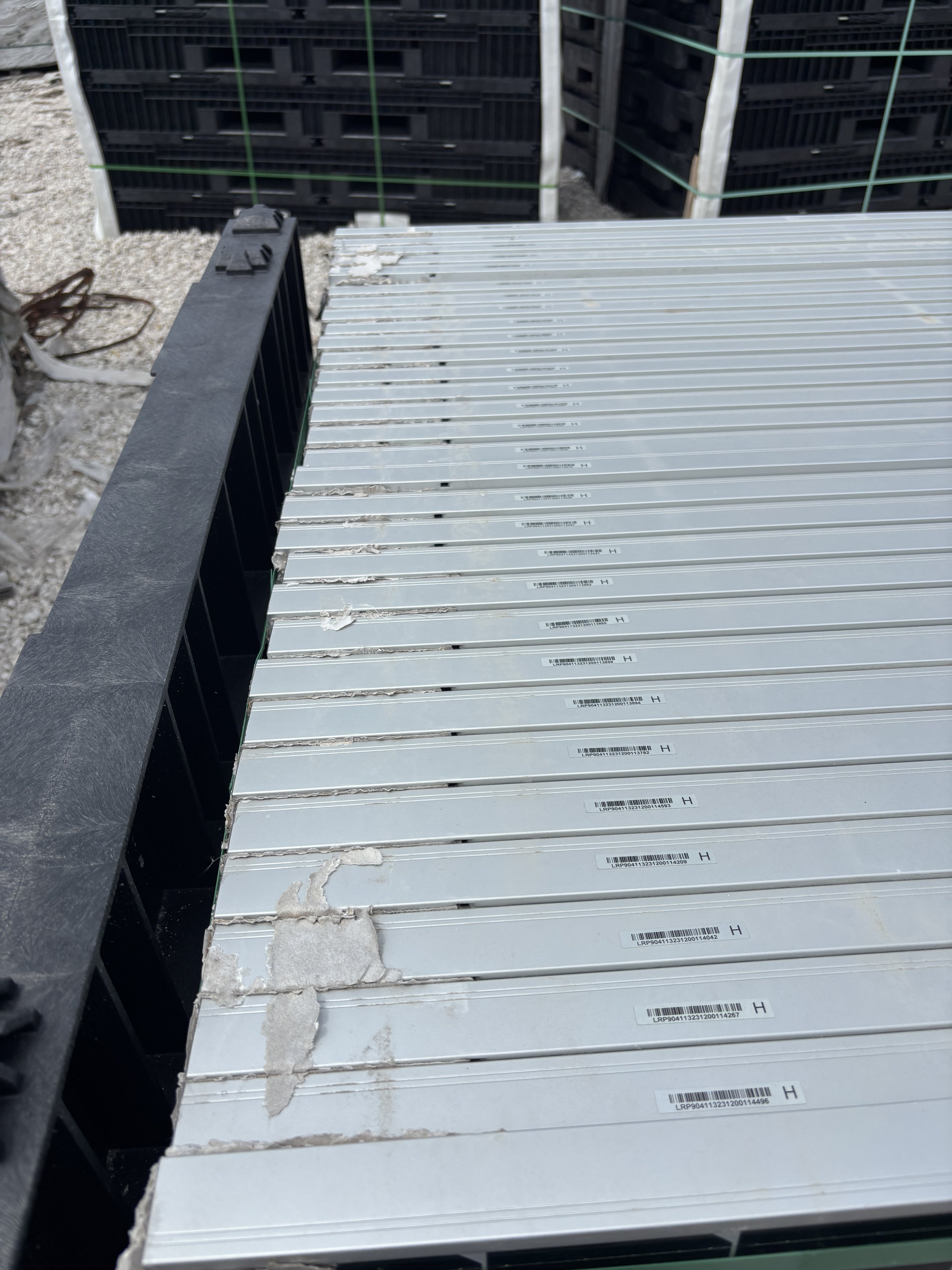Solar panels stacked on PVpallet reusable pallets, organized for barcode scanning and inventory tracking