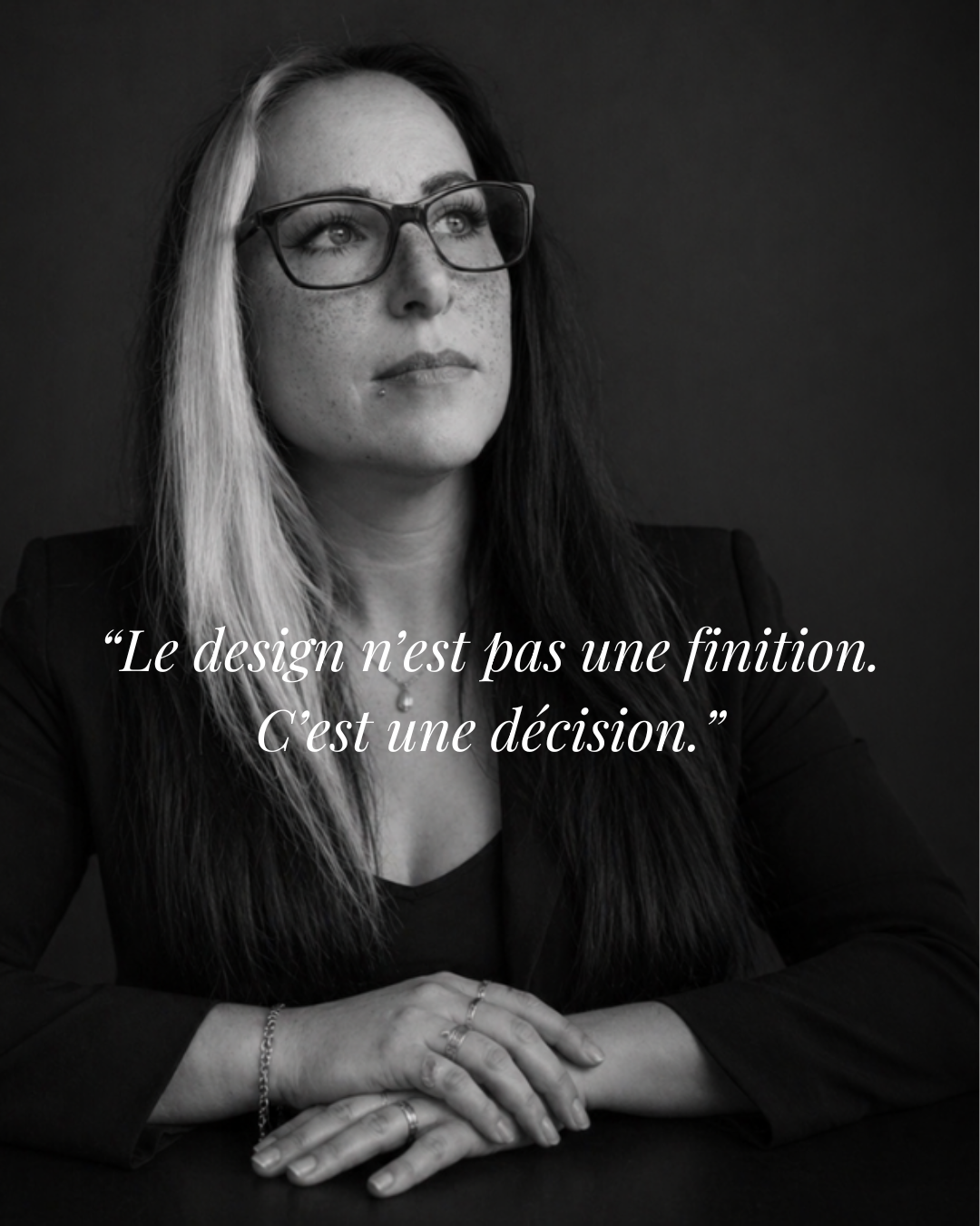 Une femme portant des lunettes, avec des cheveux mi-longs, dit une citation en français sur le design, en noir et blanc.
