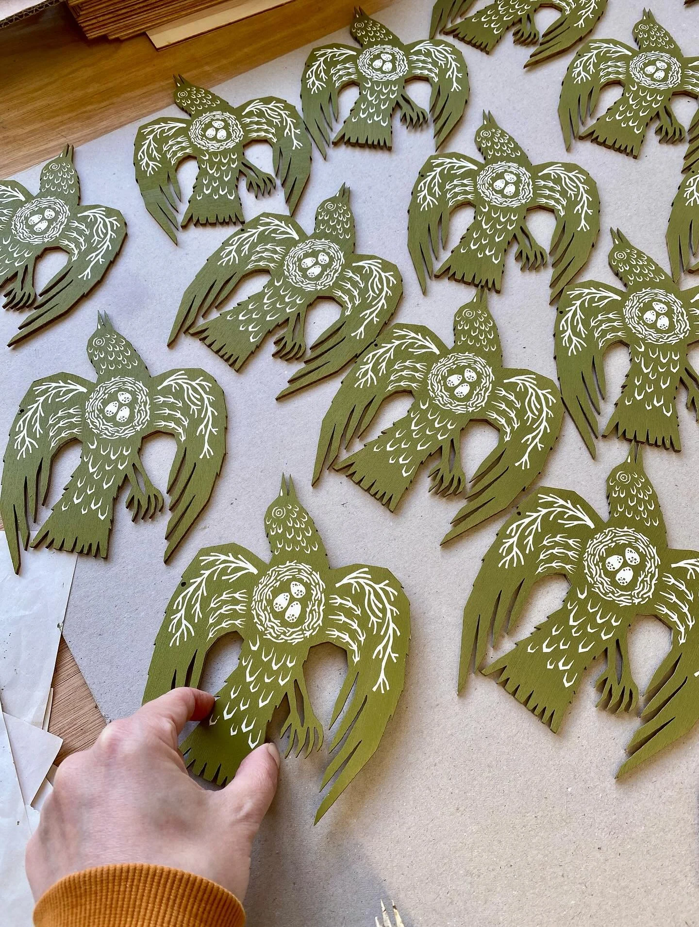 Woodland bird freshly pressed! Screenprinted on both sides in a lovely olive green ink and strung with old gold waxed cotton thread. We love the idea of our swooping bird decorating your home - its wings filled with branches and a clutch of eggs, all