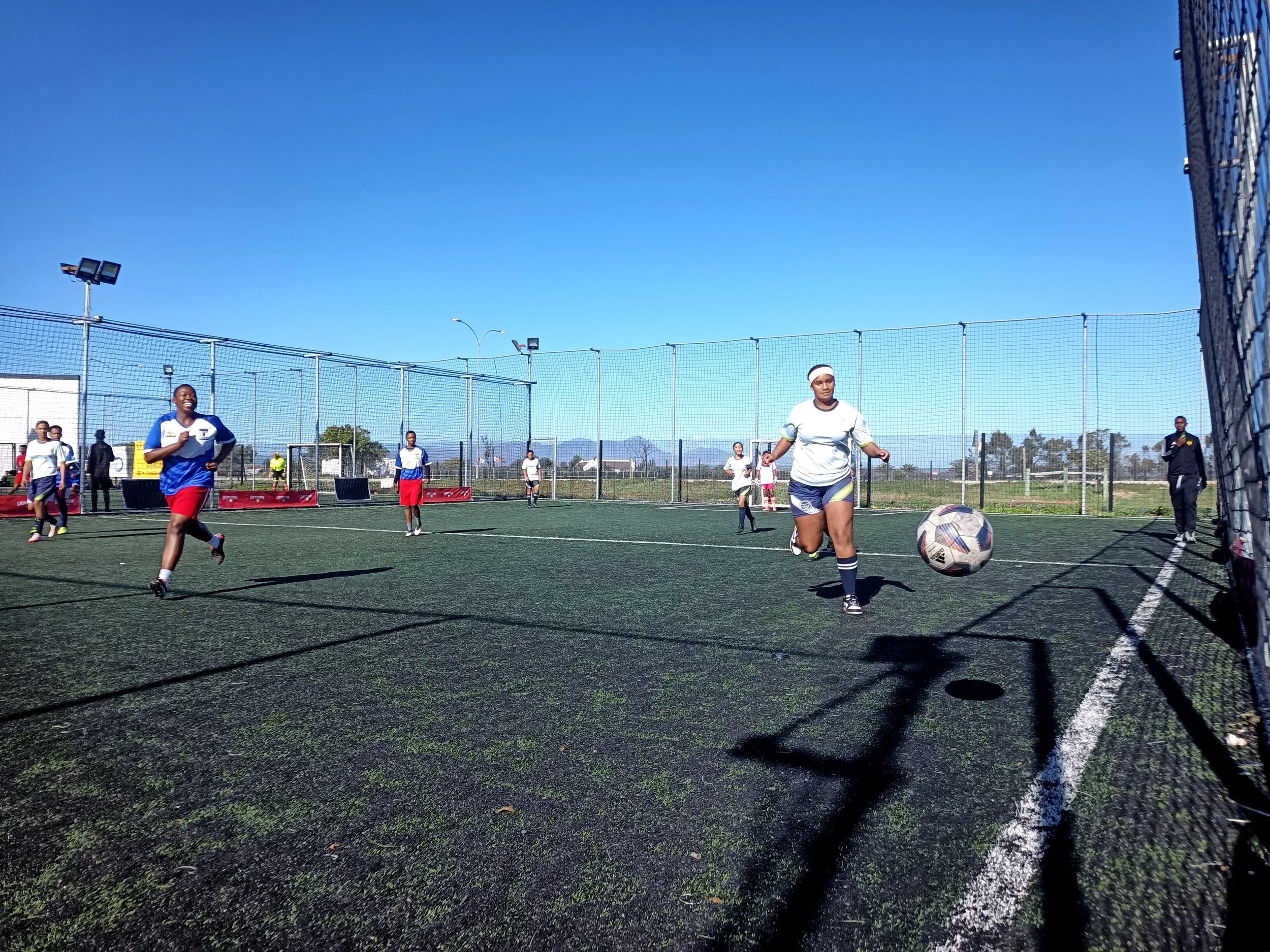  Girls playing soccer in a court. 
