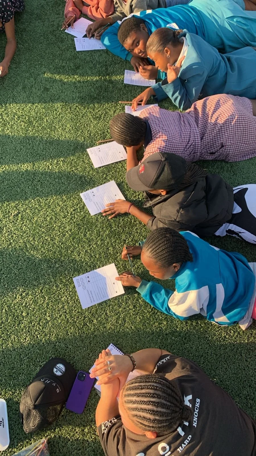 Participants lying on the grass writing during a session. 