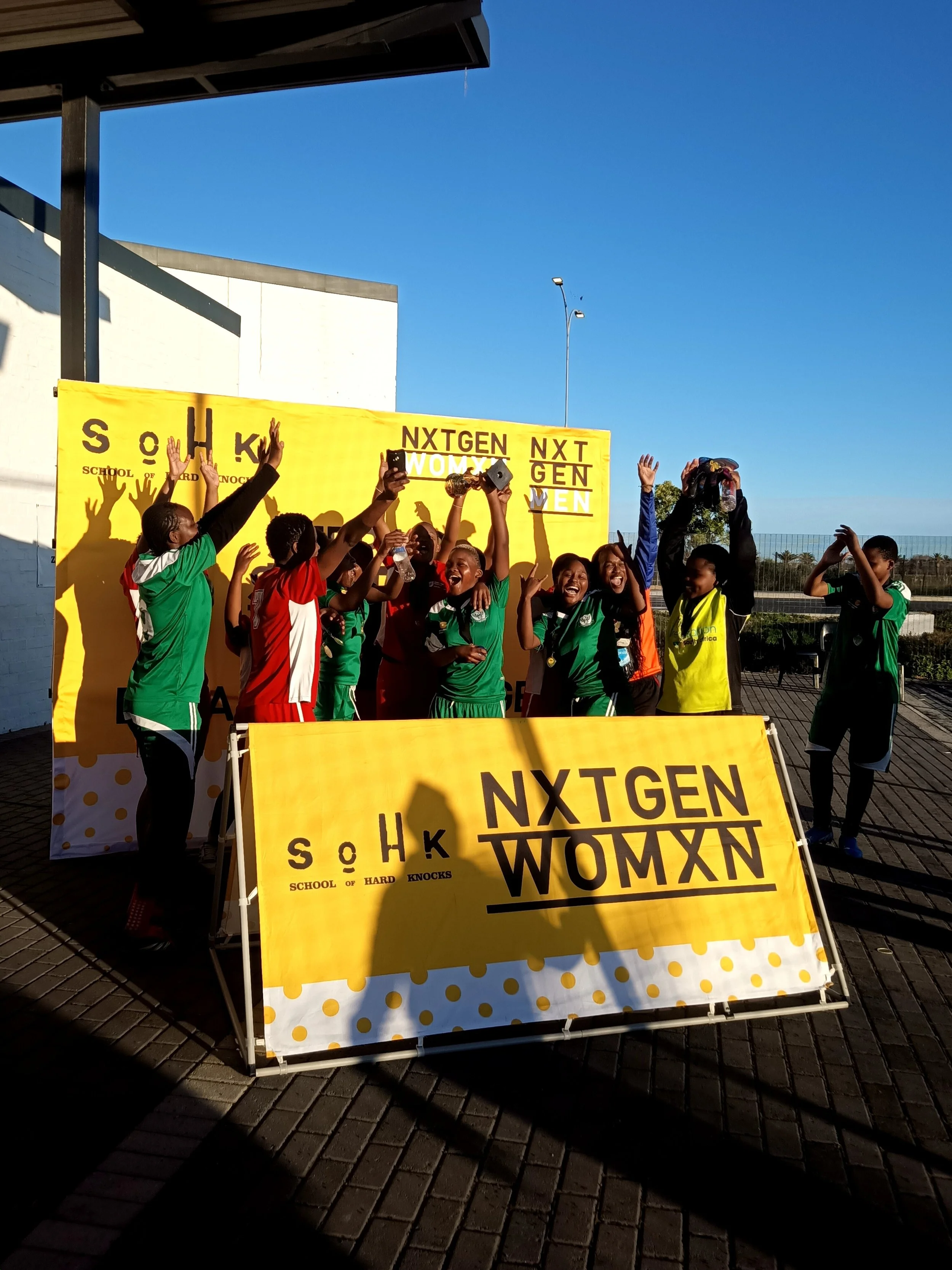 Team of girls celebrating enthusiastically with a trophy. 