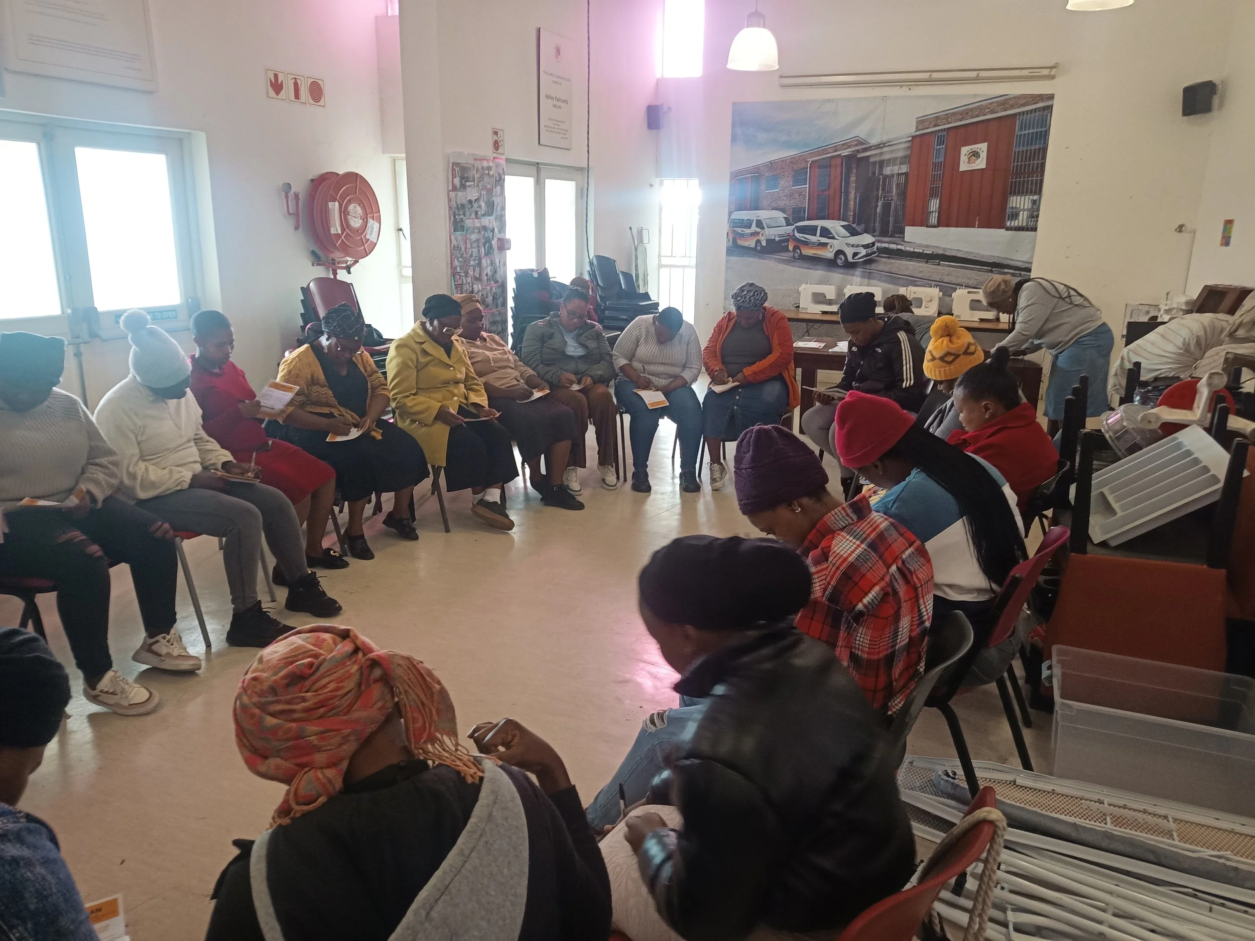  Participants sitting in a large circle during an indoor session. 