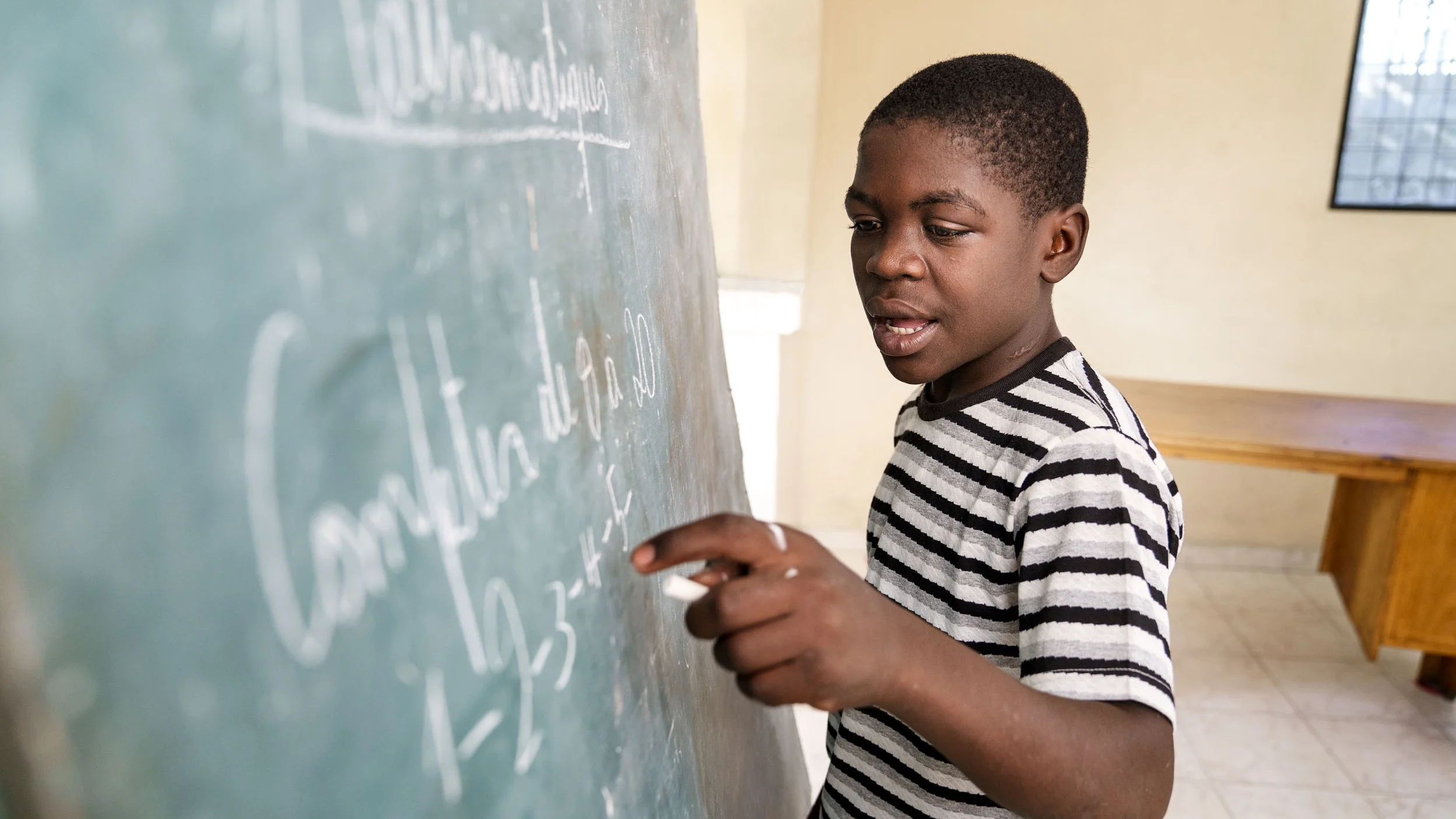From the streets to a transitional LFBS safehouse and now reunited with his older siblings, Stanley is making remarkable personal growth. With literacy tutoring, he is now attending school. Photo by GBP Creative. © 2019 Shot In The Dark Media.