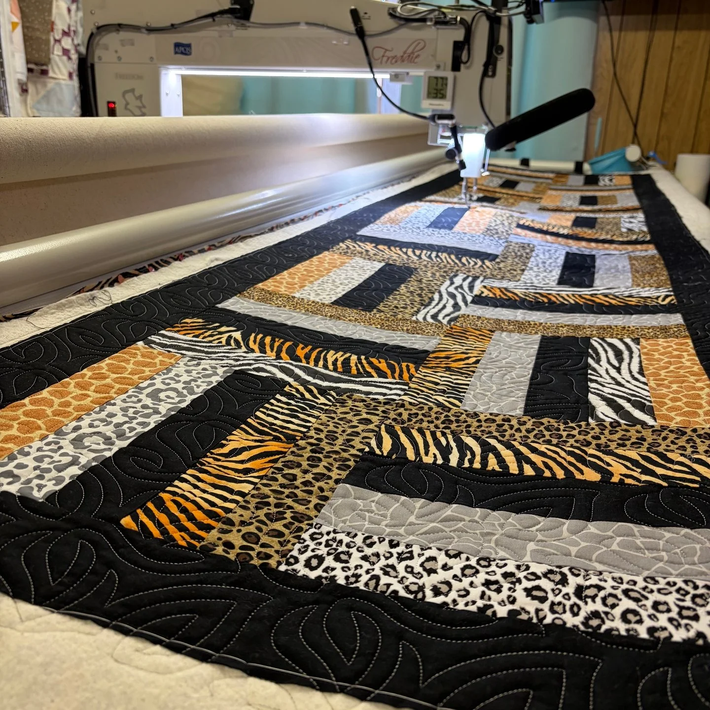 Ellen dropped off this amazing bed runner and I was glad to get to quilt it for her!

I love the fabrics and the pattern and panto all tie together so well!

It is a HUGE runner, but that was no problem for Freddie! If you didn't know, I can accommod