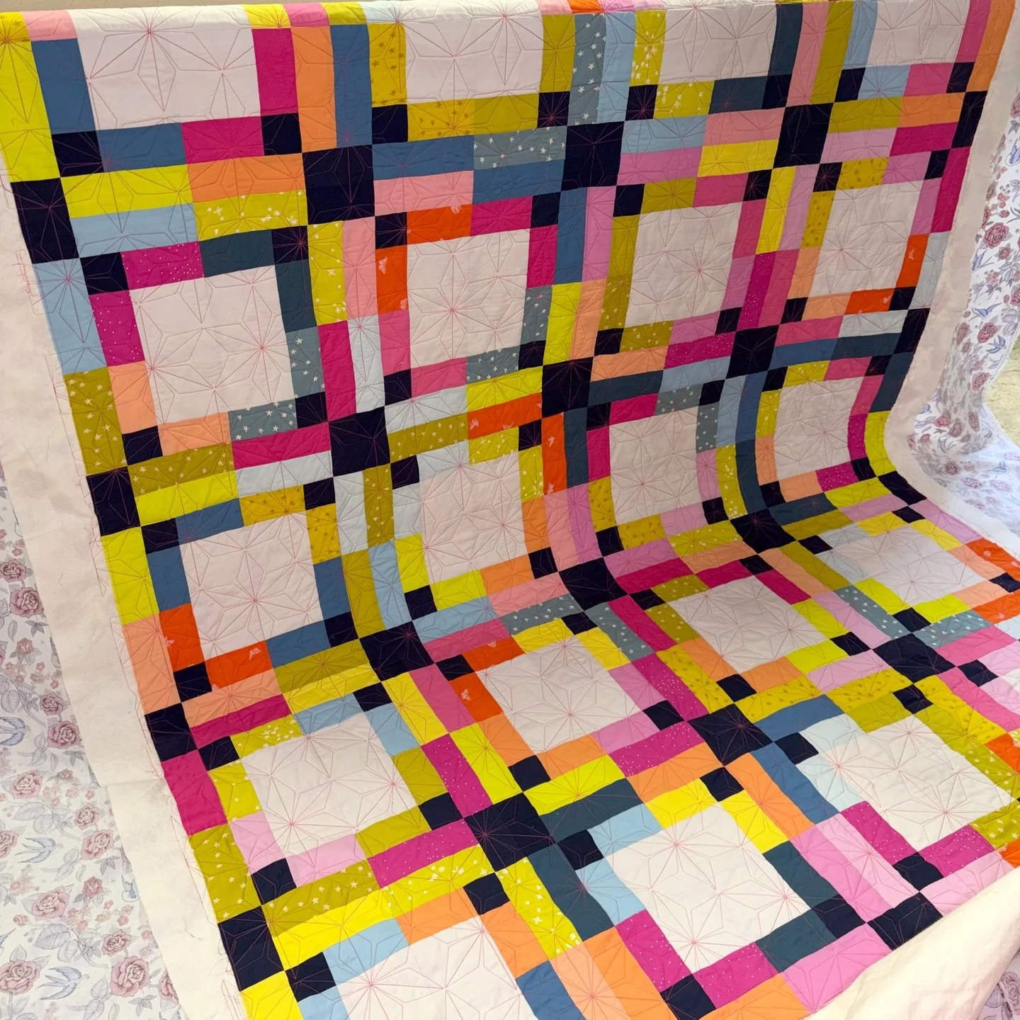 This bright and bold quilt is Jenny's pattern, Bonnie Twist, and I loved getting to quilt it for her!

This is the second version she sent me, and I love them both!! For this one, she went with a bold pink thread and I love how it POPS on that lighte