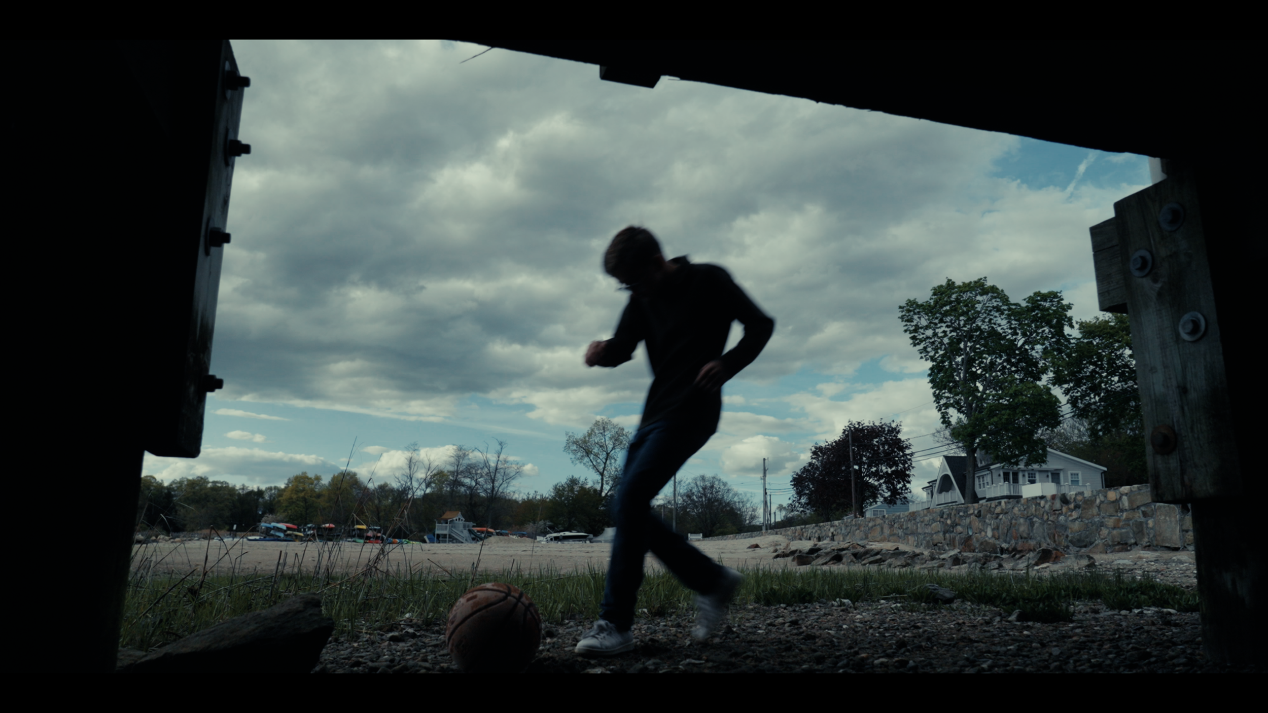 Boy running towards basketball in a Wide Shot