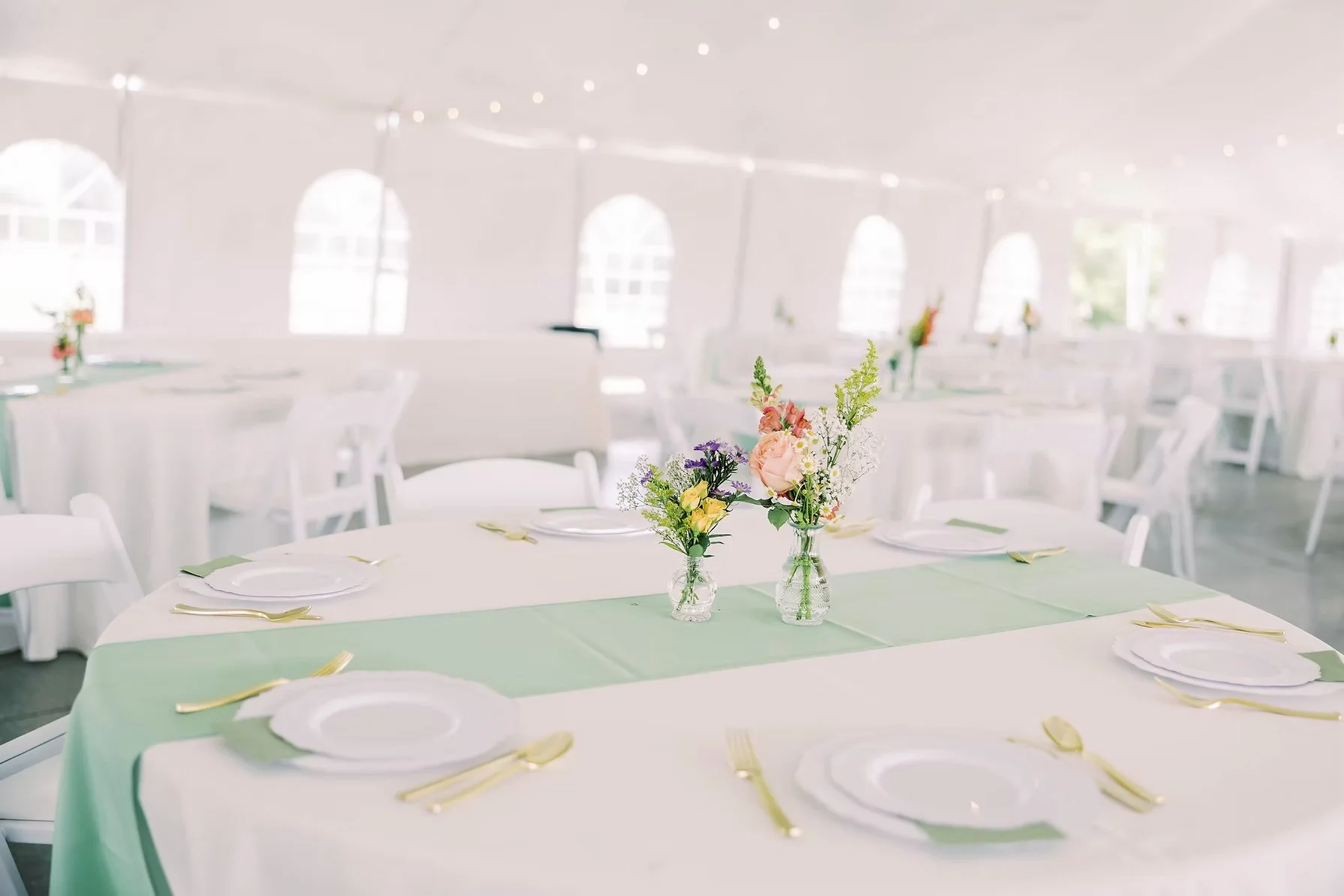 beautiful table setting under white tent gold utensils sage highlights.jpeg