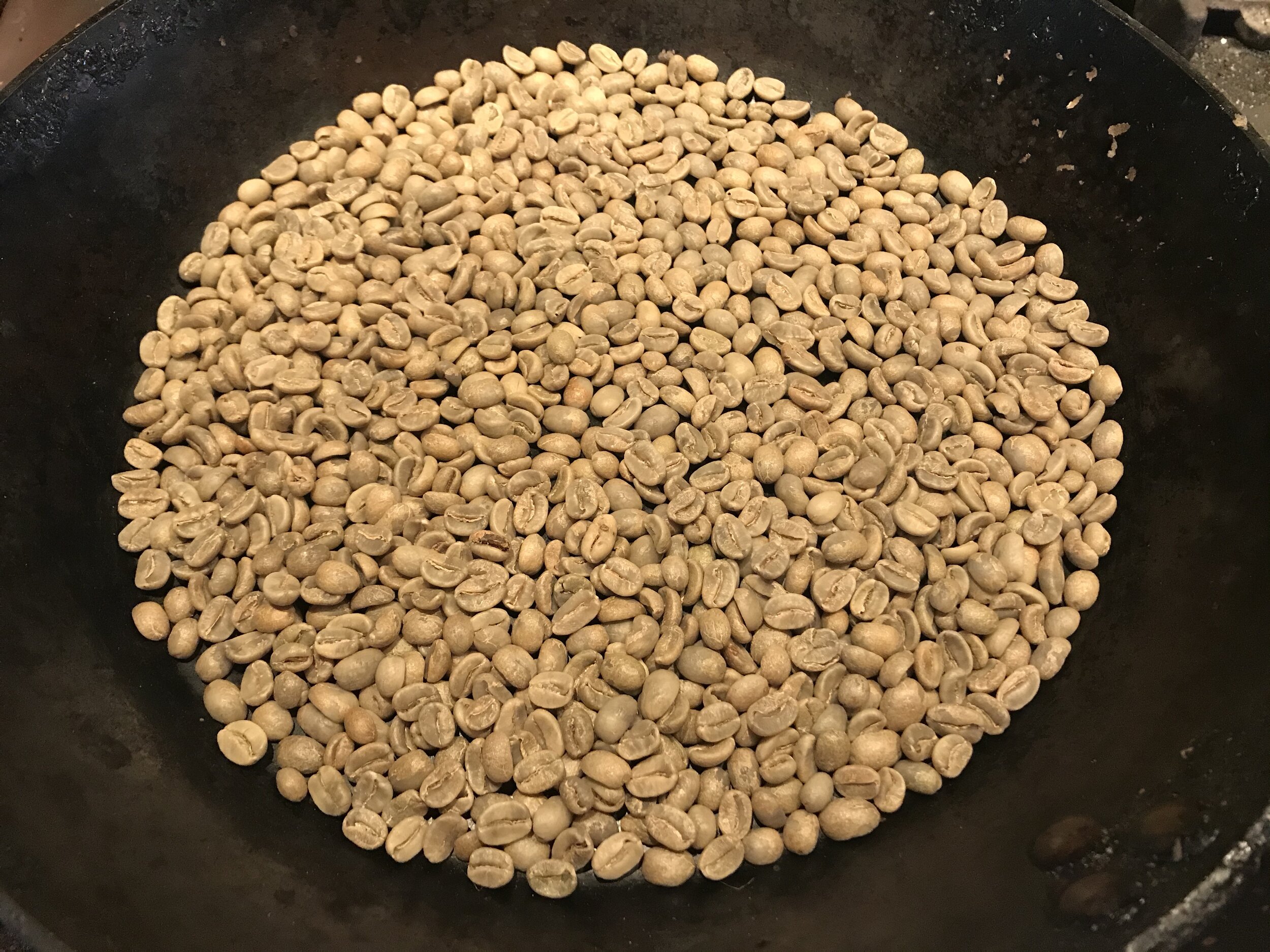  We used a carbon-steel pan, which is lighter than a cast iron pan, and is angled sides allow for easy and constant flipping of the beans for an even roast. We use a full burner with the exhaust fan on high until the beans turn brown, and then we low