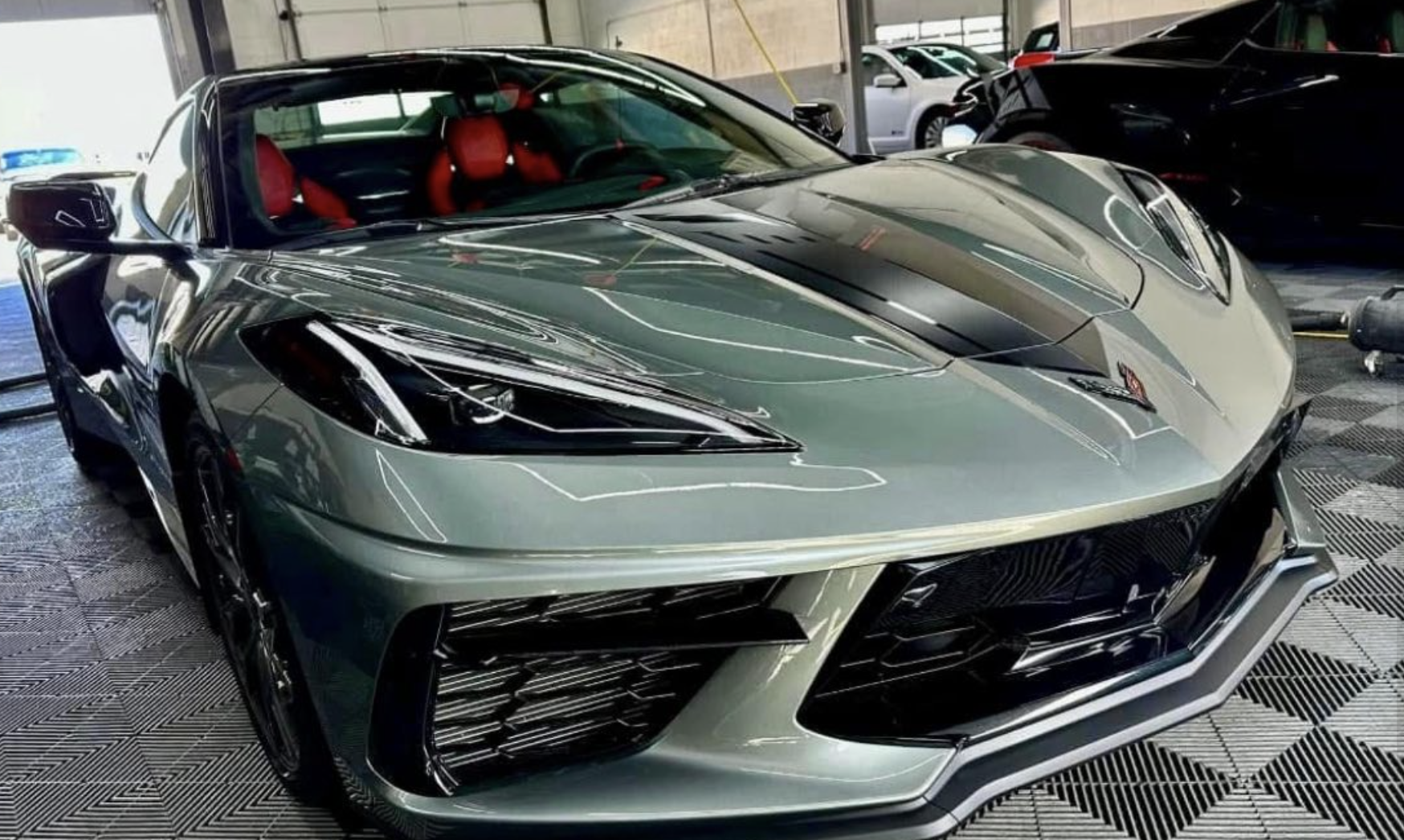Corvette C8 with sleek design and red interior, showcased in an auto detailing shop, emphasizing vehicle protection with Paint Protection Film (PPF).