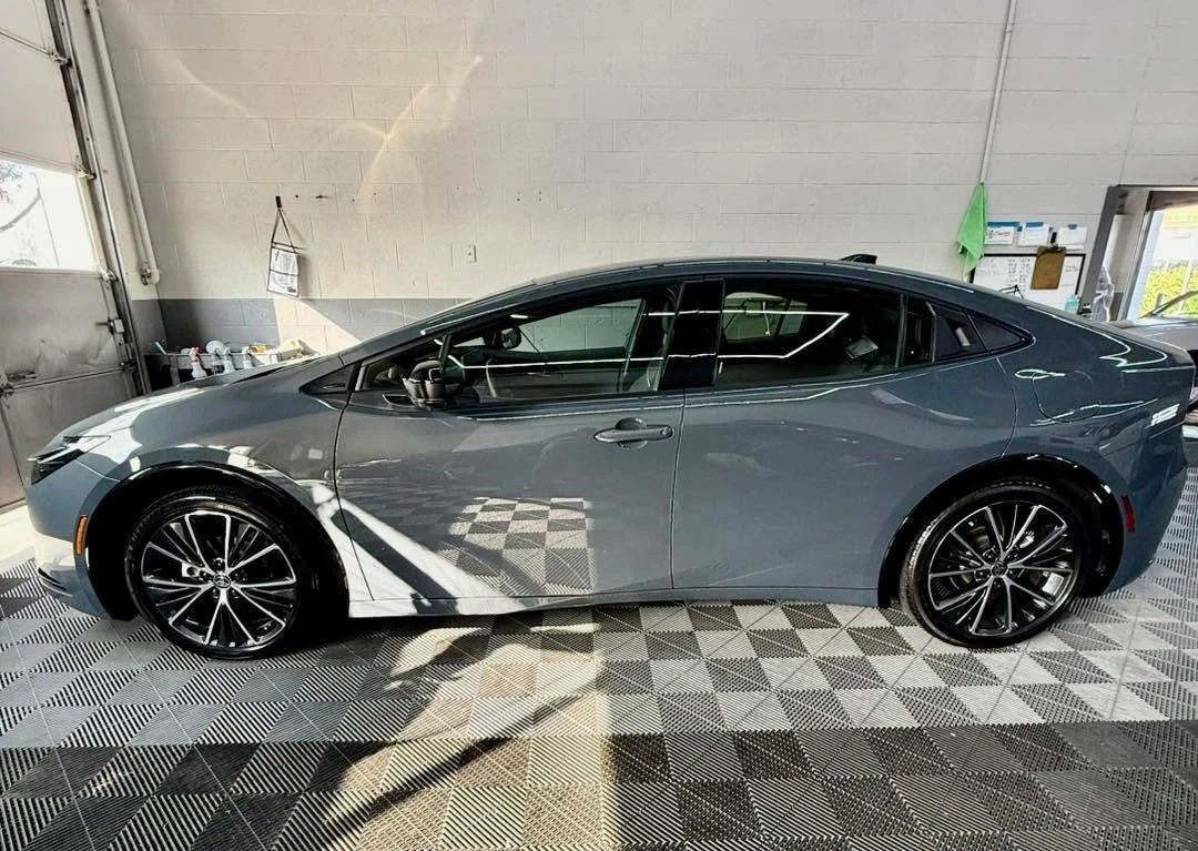 Gray vehicle in a clean detailing shop, showcasing its shiny paint, highlighting the benefits of paint protection film for car owners.