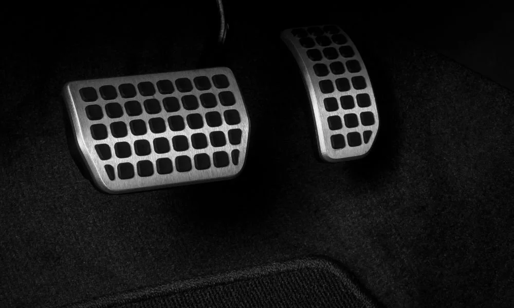 Close-up of car pedals, highlighting overlooked areas in car detailing, emphasizing cleanliness and attention to detail.