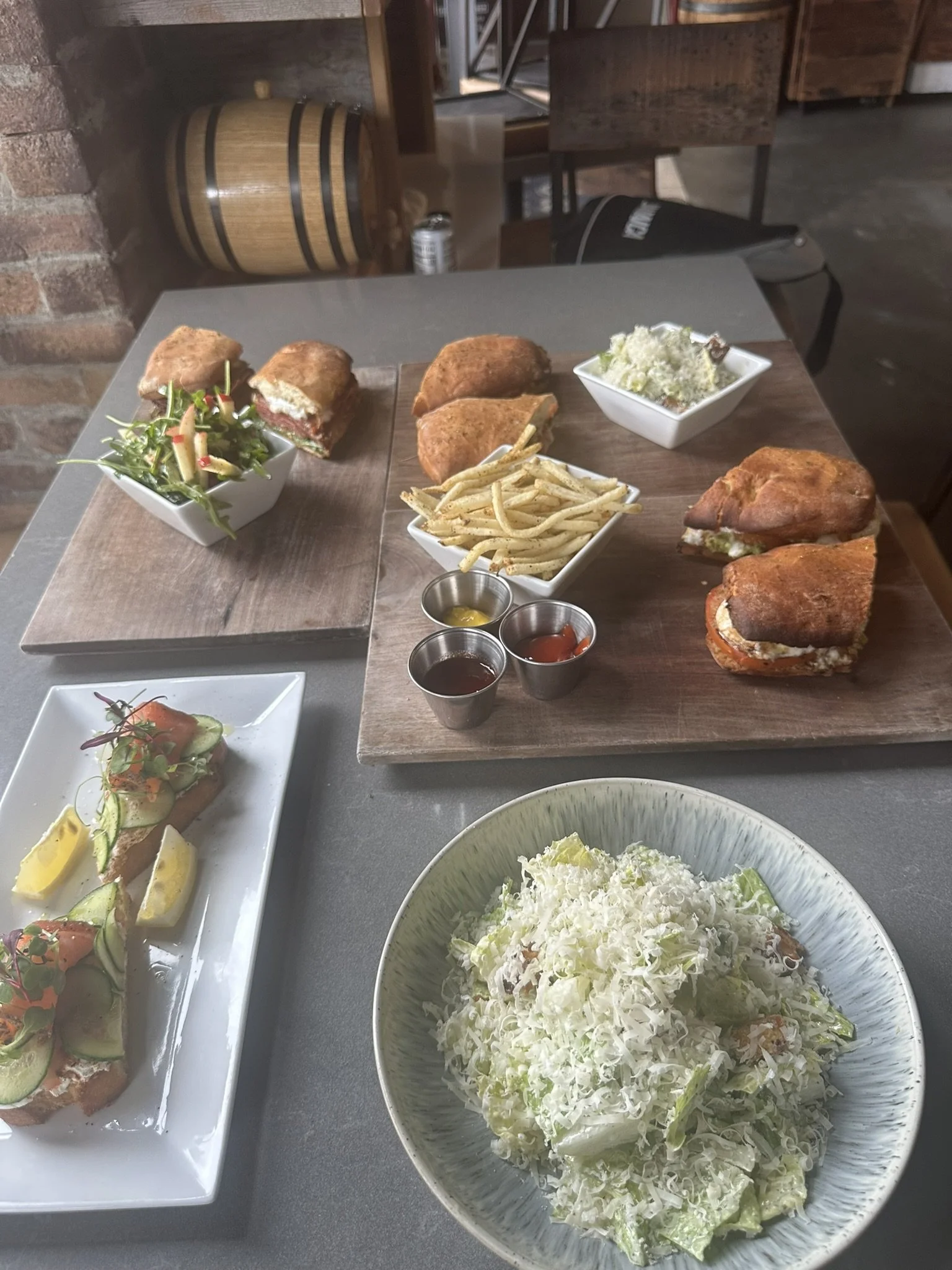 A table with various dishes, including fried foods, fries, salad, and sauces, in a restaurant setting.