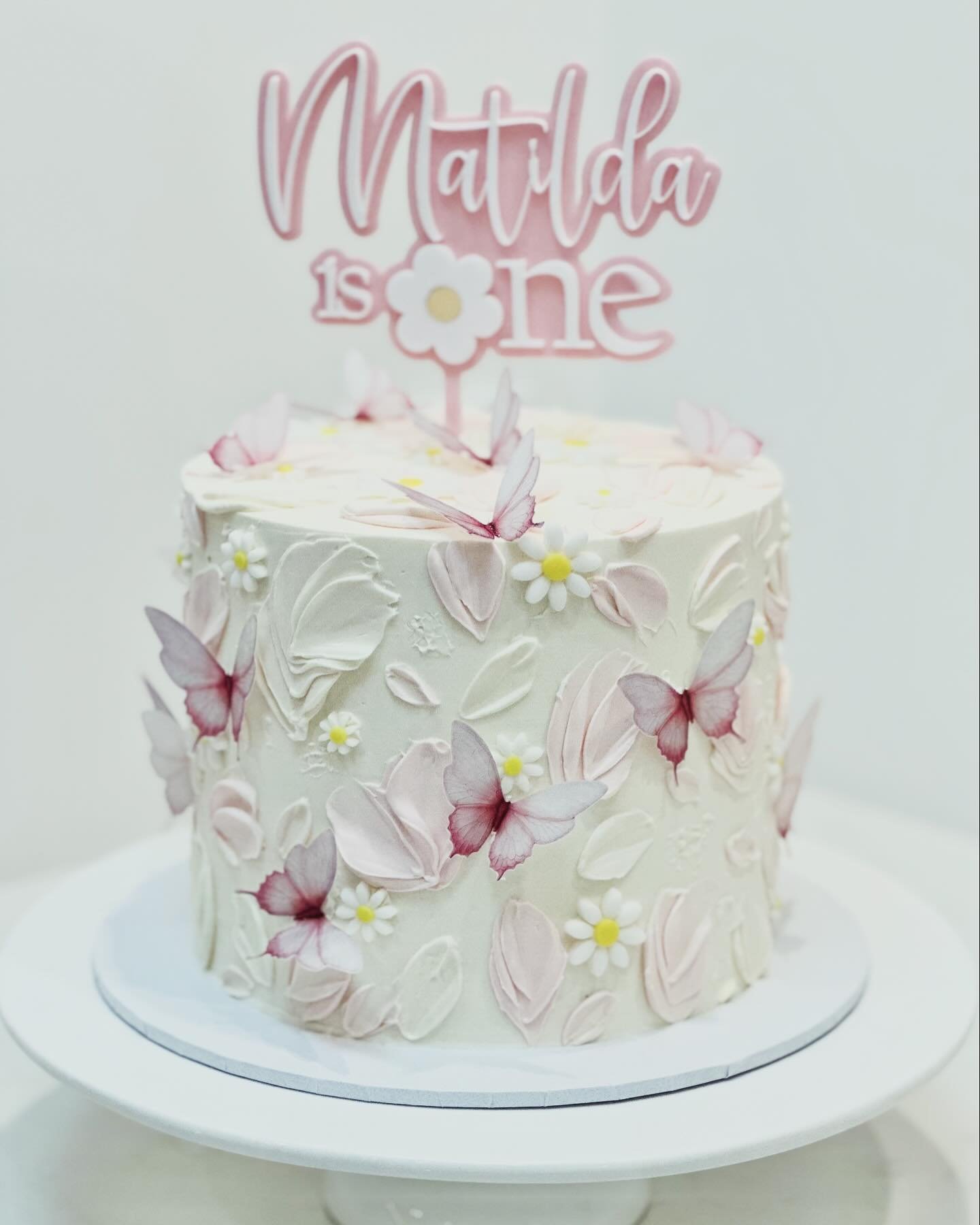 A magical 1st Birthday cake for sweet Matilda adorn with delicate daisies and fluttering butterflies. Thank you to @sweettoothmelbourne  for the prettiest cake topper and wafer paper butterflies from @moreish.cakes. #firstbirthdaycake #daisycake #but