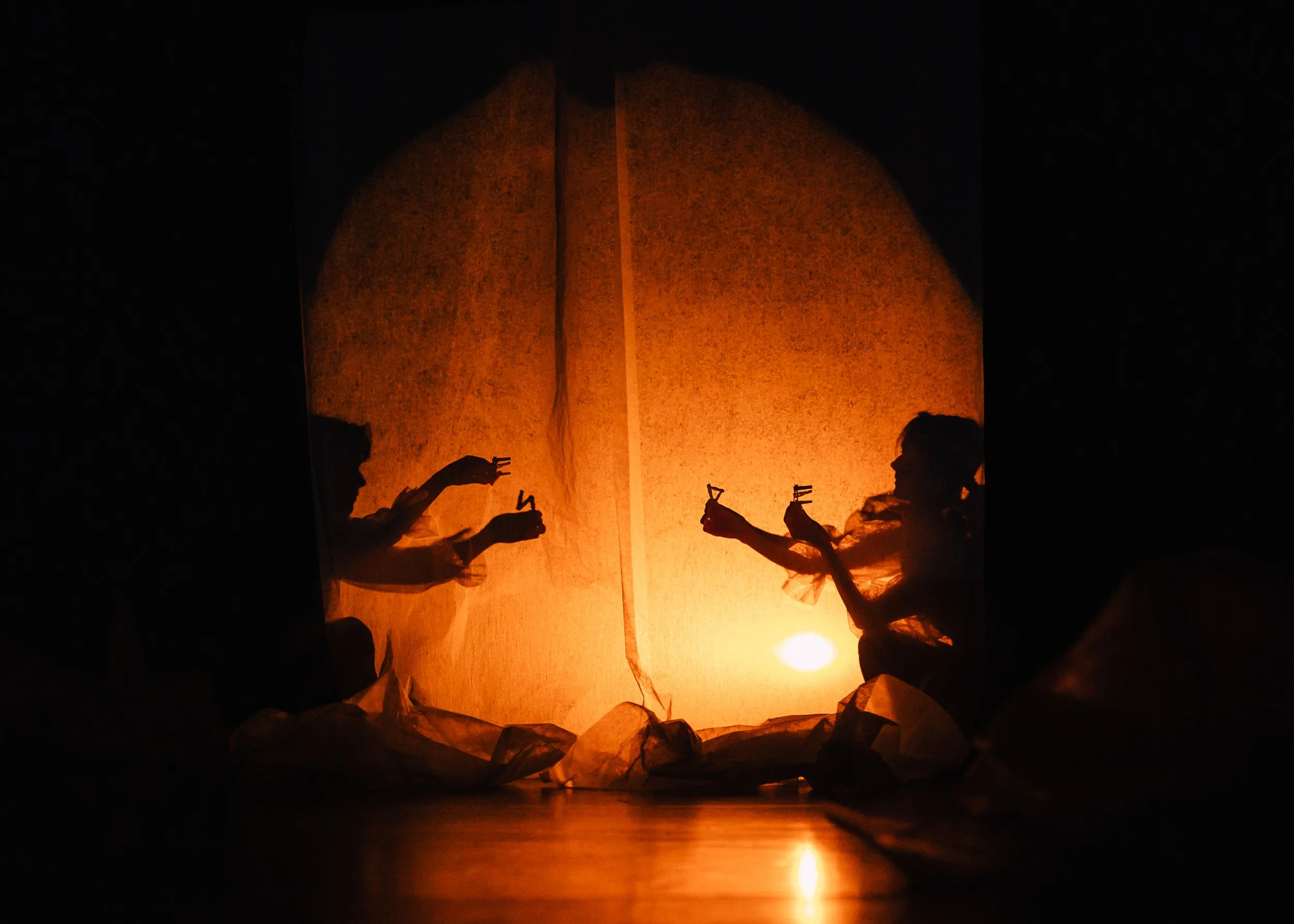 Children and adults releasing paper lanterns into the night sky during a festival or celebration.