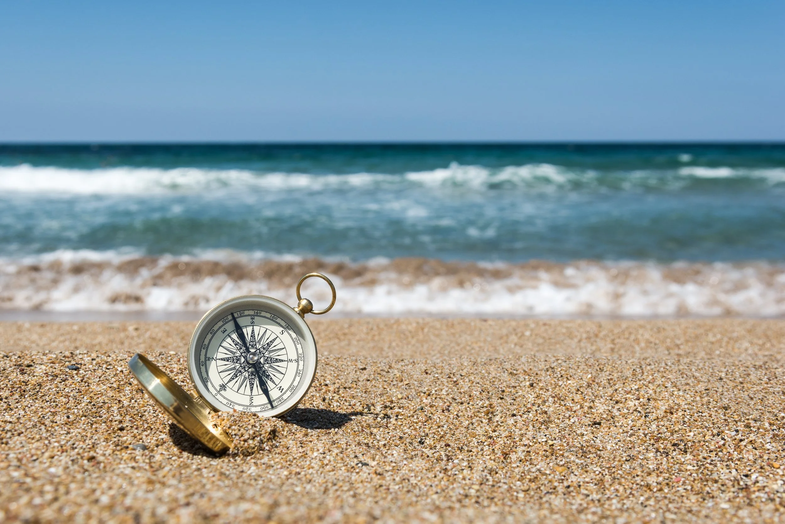 64335299 XL -compass-on-the-golden-sand-by-the-sea.jpg