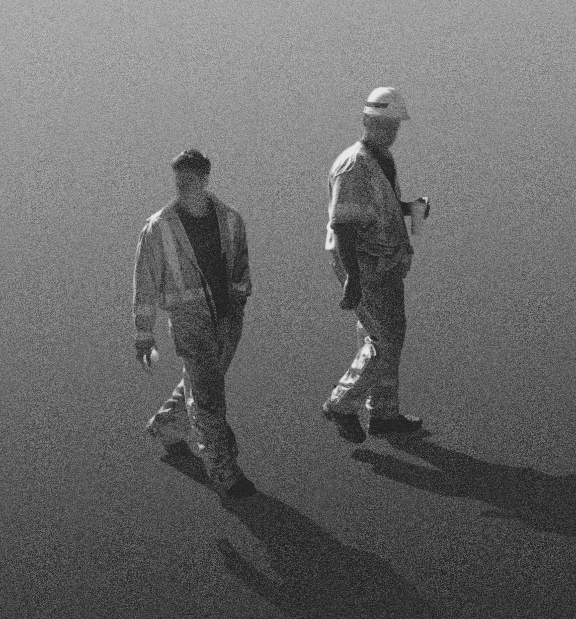 Workers in Jumpsuits Walking Through Street - Ridgewood