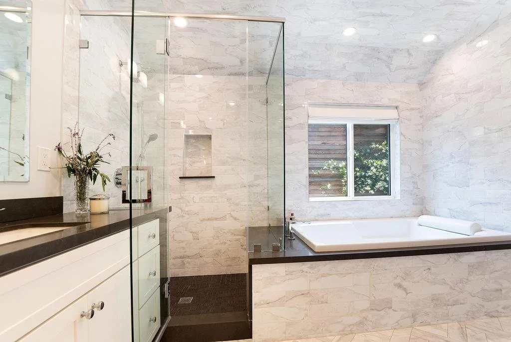 Los Angeles primary bathroom with vaulted, tiled ceiling, featuring a shower with quartz bench and tiled niche, and drop-in bathtub with quartz deck continuing from the shower bench.