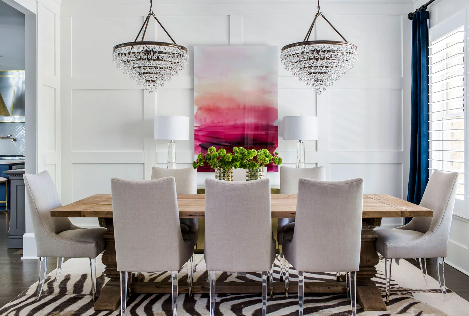Contemporary elegant dining room with lucite dining chairs and rustic dining table