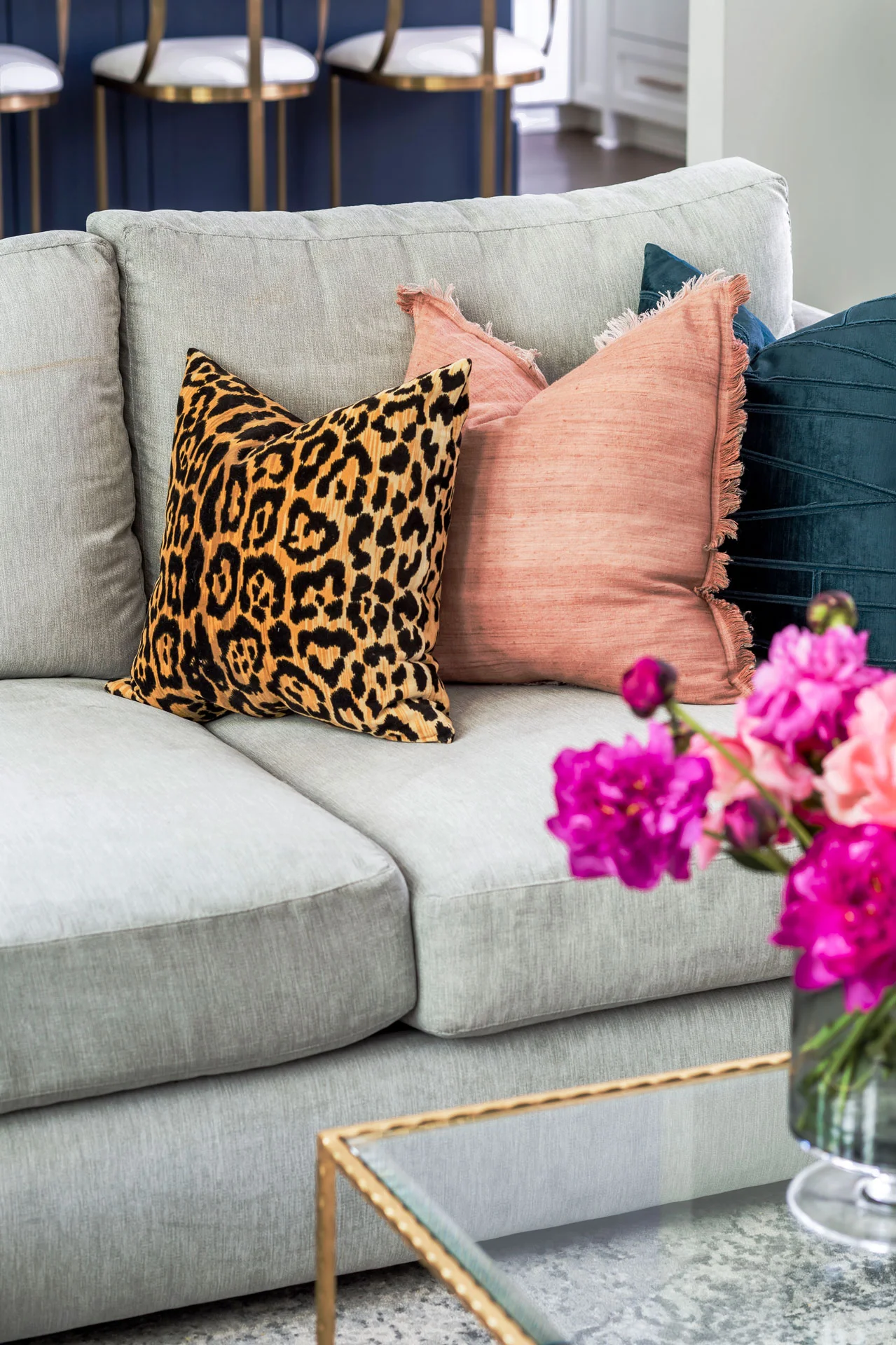 Grey velvet sectional with colorful printed throw pillows