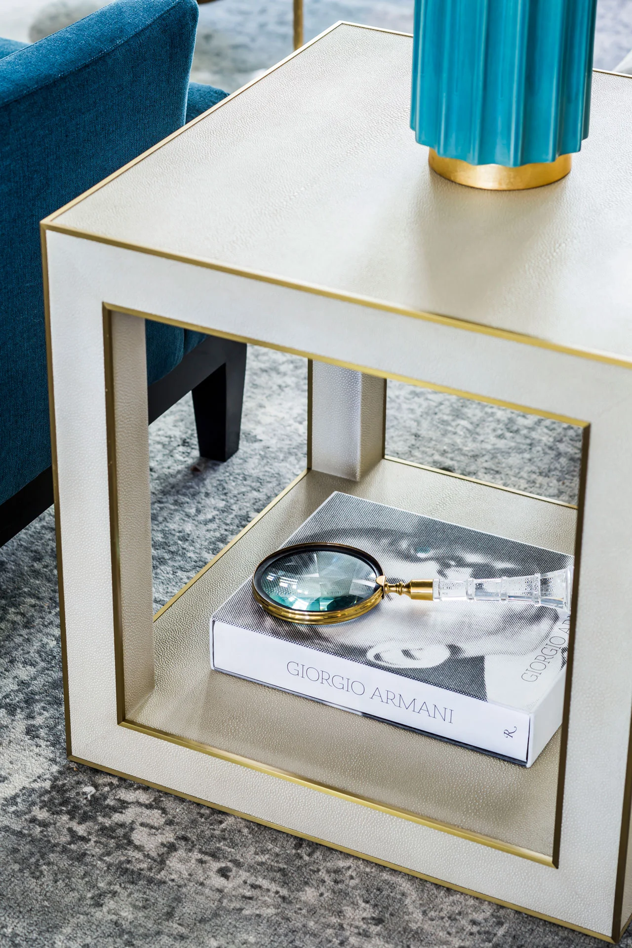 White Restoration Hardware shagreen side table with coffee table book and turquoise lamp
